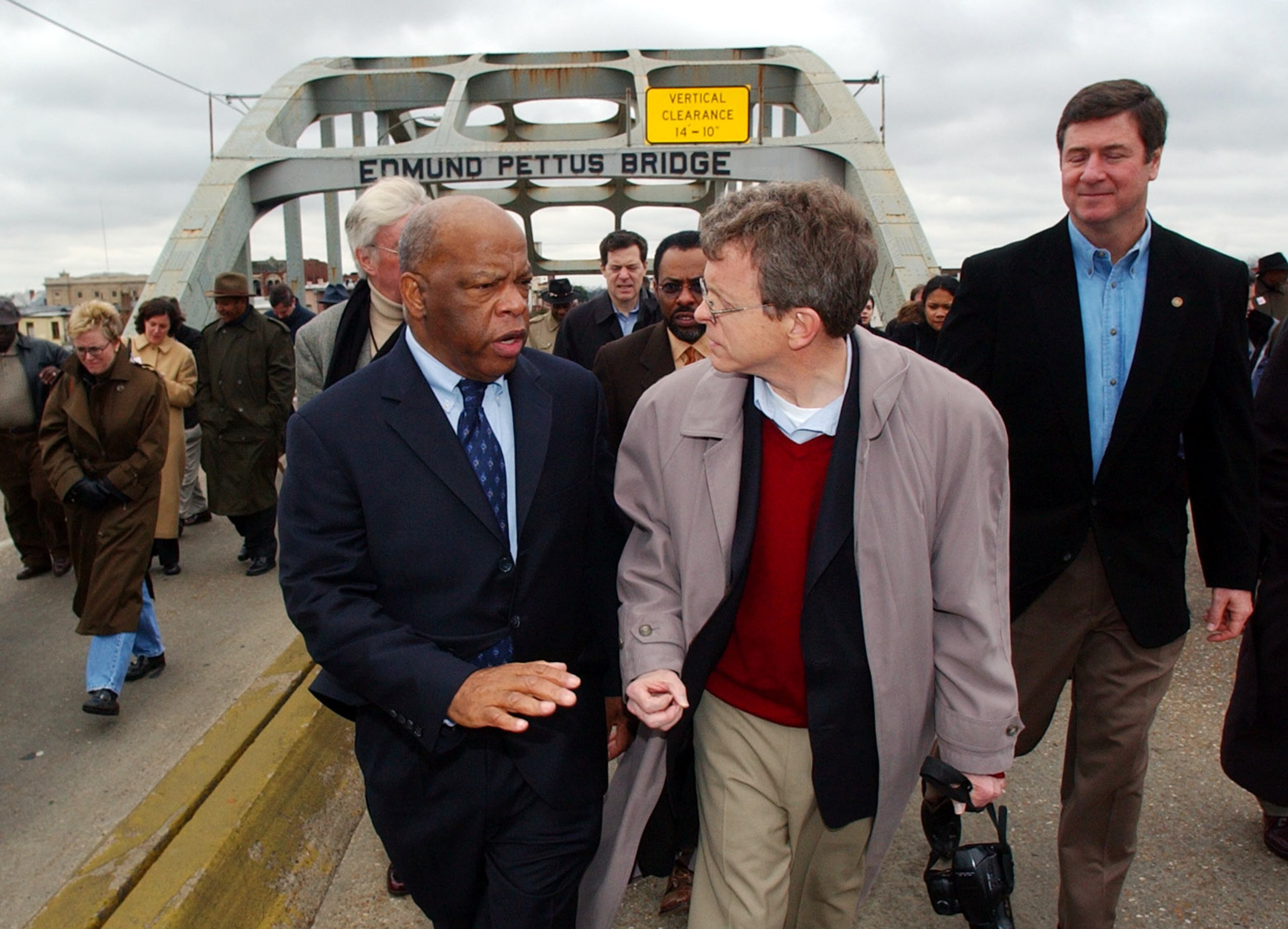 U.S. Rep. John Lewis, D-Ga., left, explains to Sen. Mike Dewine, R-Ohio, about the events that took place in 1965 when marchers were beaten by Alabama State Troopers when they attempted to cross the Edmund Pettus Bridge in Selma, Ala., during what became known as 'Bloody Sunday'. At right is Sen. George Allen, R-Va. Lewis was giving a group of senators a tour of historic civil rights locations in Alabama on Saturday, Feb. 14, 2004. (AP Photo/Dave Martin)