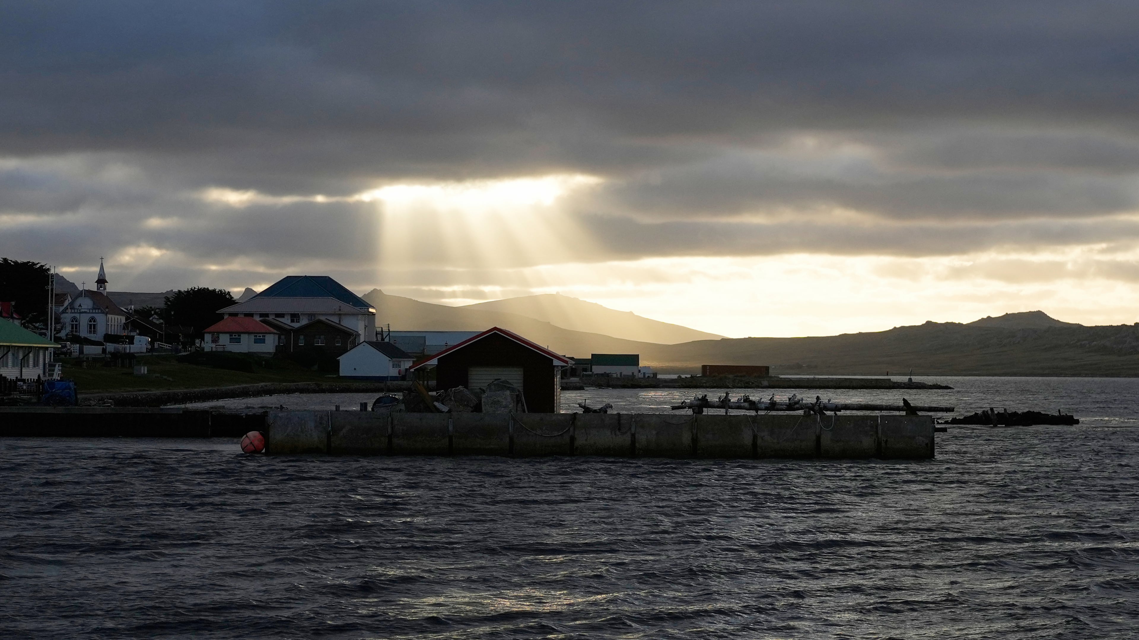 FILE - Sunlight breaks through the clouds over Stanley on the Falkland Islands, also known as Islas Malvinas, March 14, 2026. (AP Photo/Ricardo Mazalan, File)