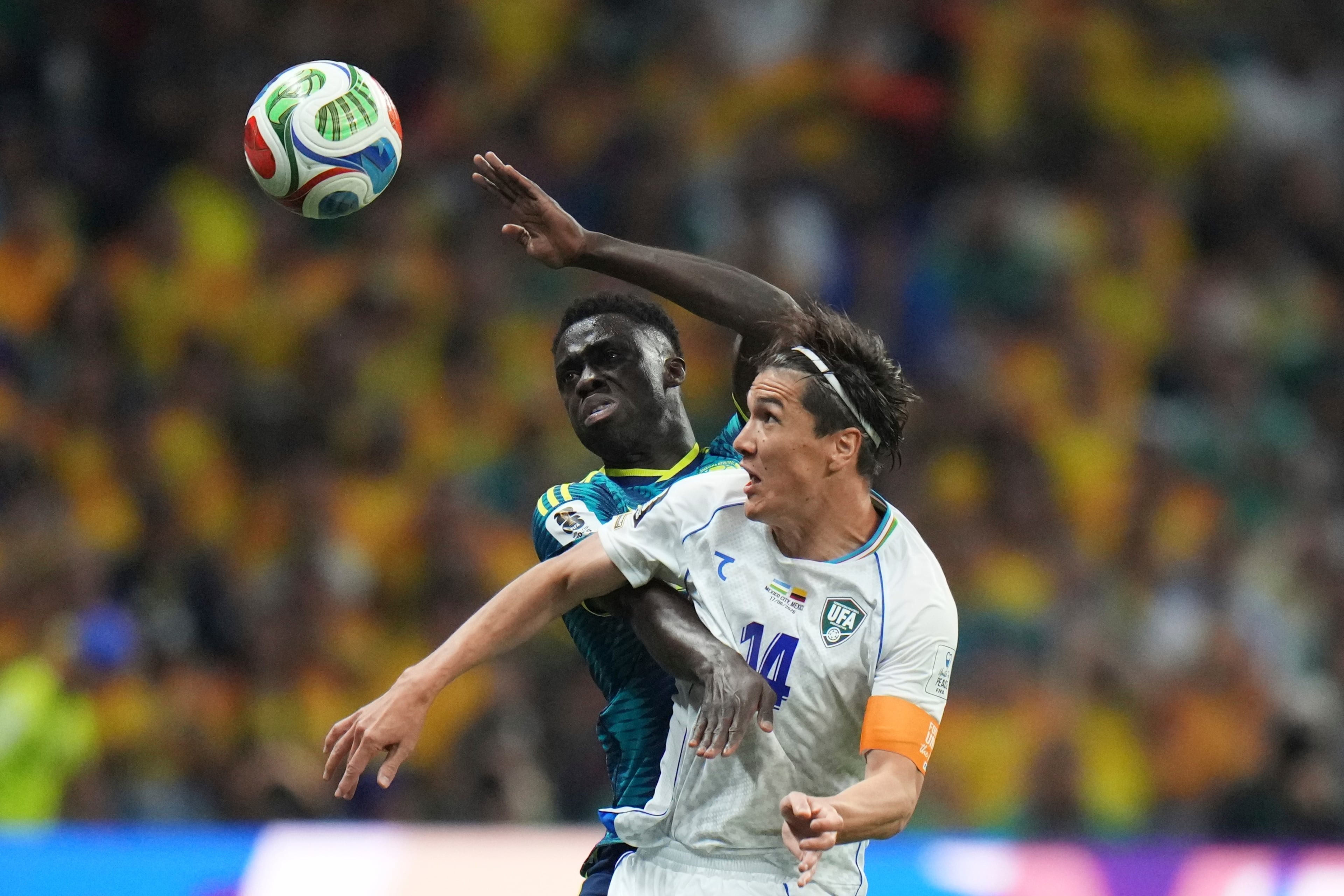 Uzbekistan’s Eldor Shomurodov (front) plays during a group stage game against Colombia. (Eduardo Verdugo/AP)