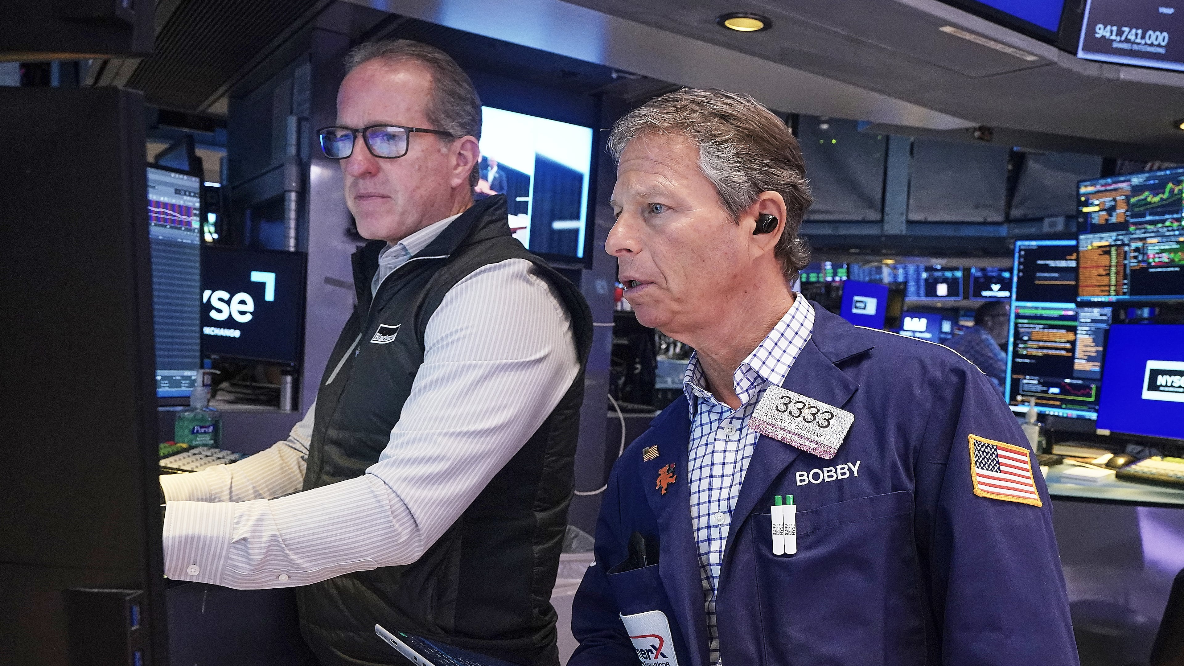 Specialist Glenn Carell, left, and trader Robert Charmak work on the floor of the New York Stock Exchange, Friday, May 22, 2026. (AP Photo/Richard Drew)