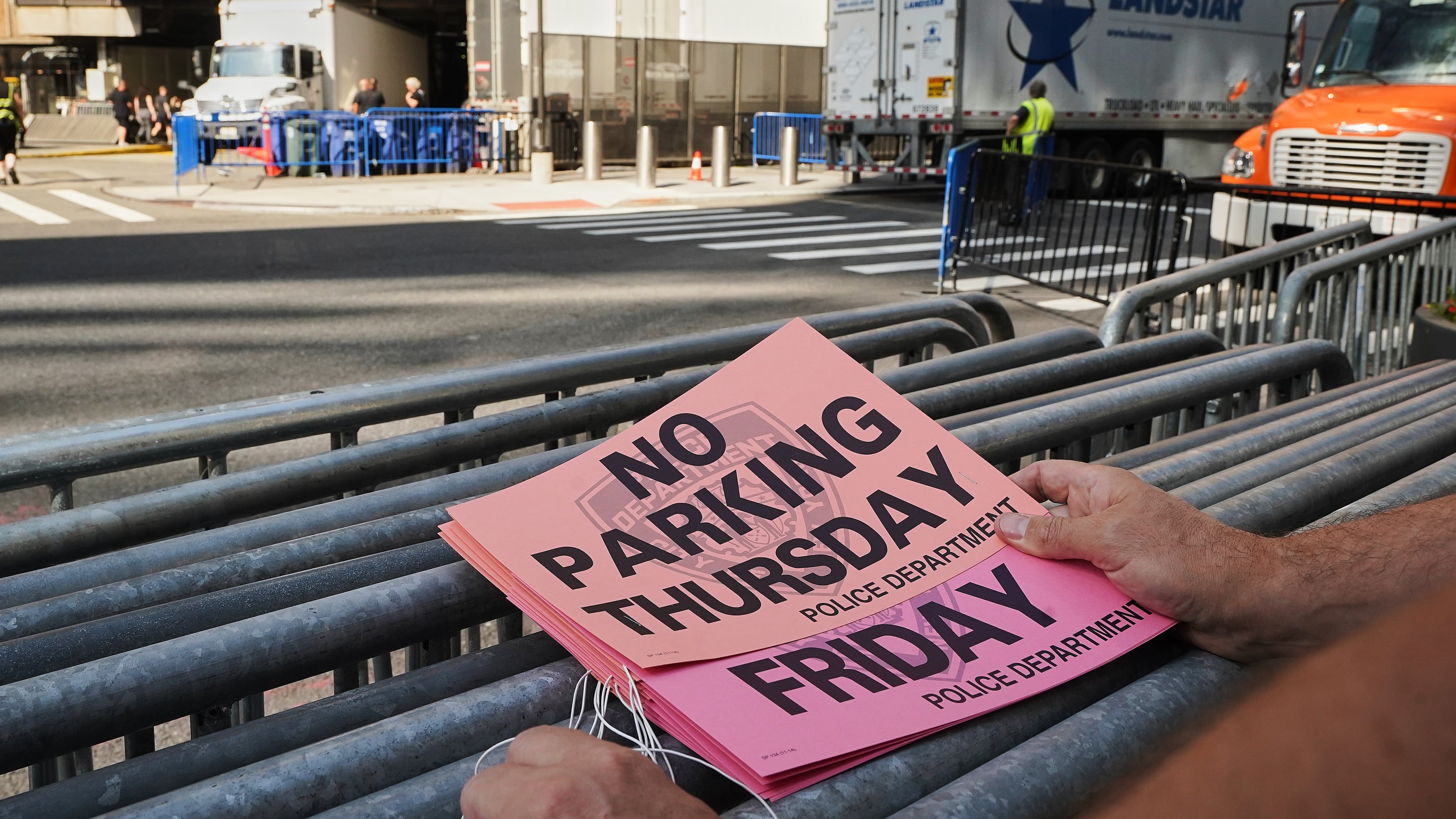 A worker holds "No Parking" signs prior to posting as trucks fill the loading dock outside New York's Madison Square Garden, Wednesday, July 1, 2026. (AP Photo/Richard Drew)