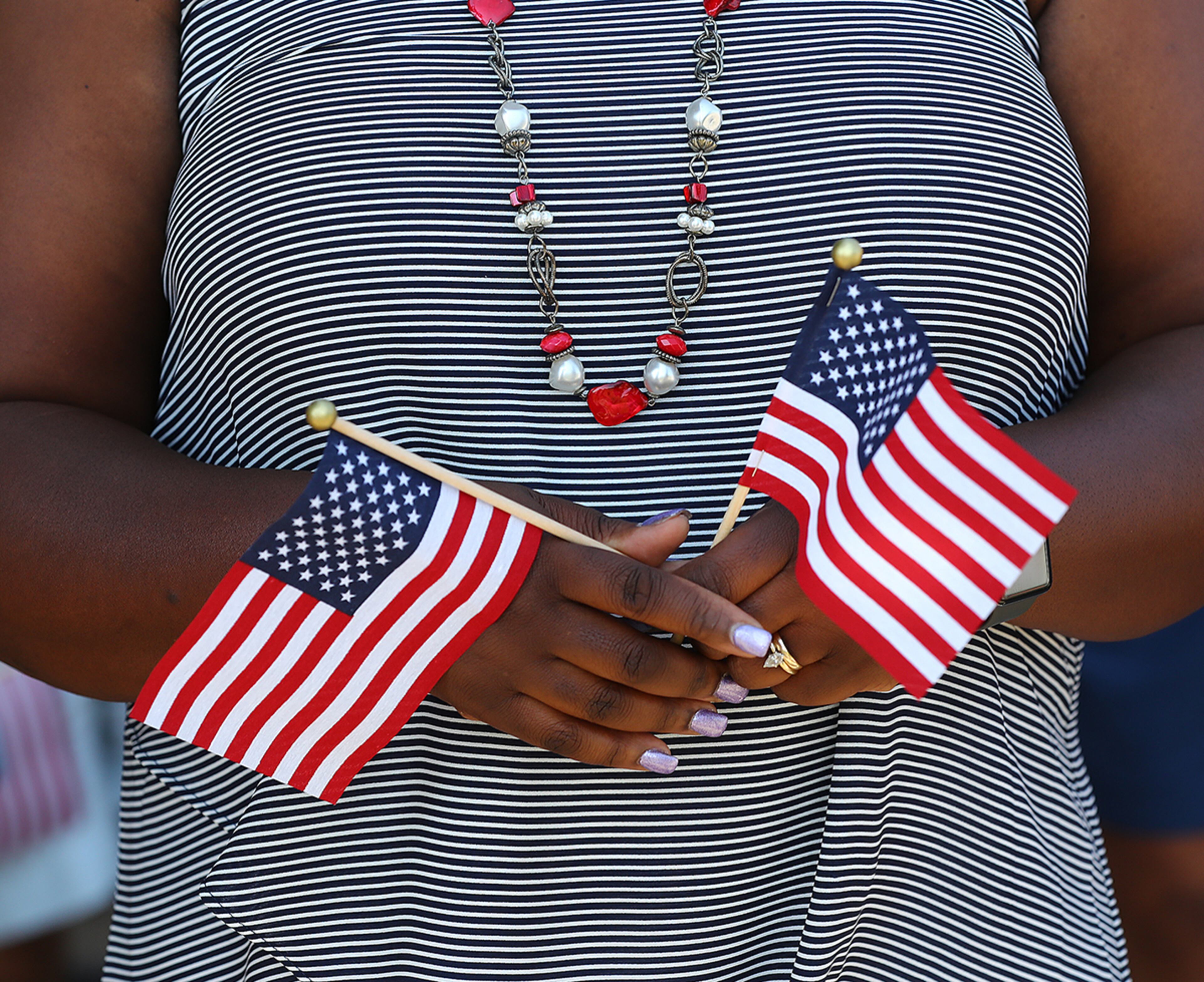 July 30, 2019 Fort Stewart: Sandra McBride holds Amercan flags for each of her fraternal twin sons Matthew and Ryan McBride while waiting for them and other soldiers with the 48th Infantry Brigade Combat Team representing units from across the state to return home from deployment to Afghanistan in support of Operation Resolute Support at Cottrell Field on Tuesday, July 30, 2019, in Fort Stewart. Matthew and Ryan McBride were bron just 45 seconds apart and have remained close ever since. Curtis Compton/ccompton@ajc.com