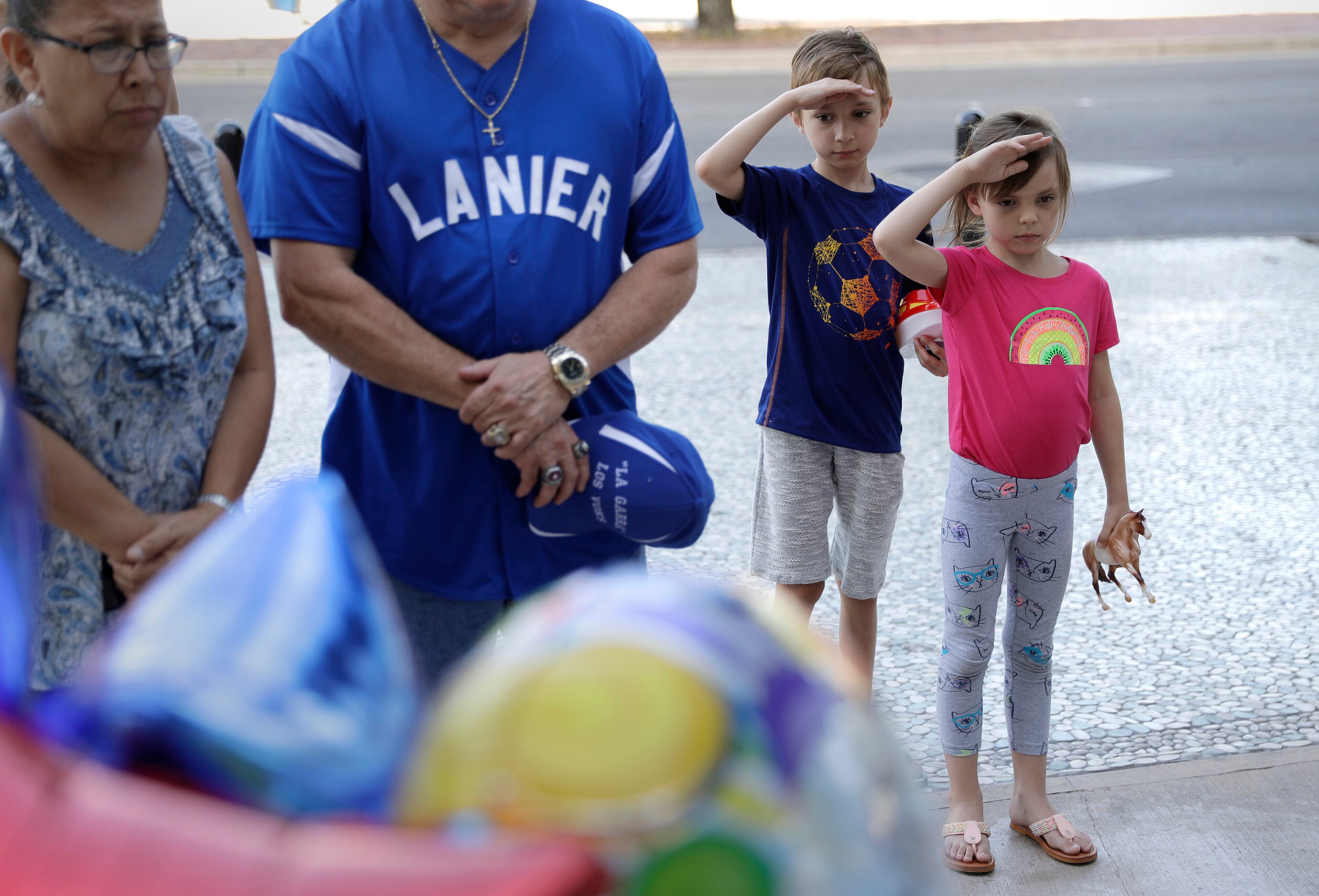 James Rutledge, 9, and his sister, Rachel Rutledge, 7, salute as they visit a make-shift memorial at the San Antonio Police Department headquarters, Friday, June 30, 2017, in San Antonio, Texas. The siblings and other visited the site to honor San Antonio police Officer Miguel Moreno who died Friday of wounds suffered when he and his partner were shot by a man they intended to question about a vehicle break-in Thursday. The suspect was killed in the shootout. (AP Photo/Eric Gay)
