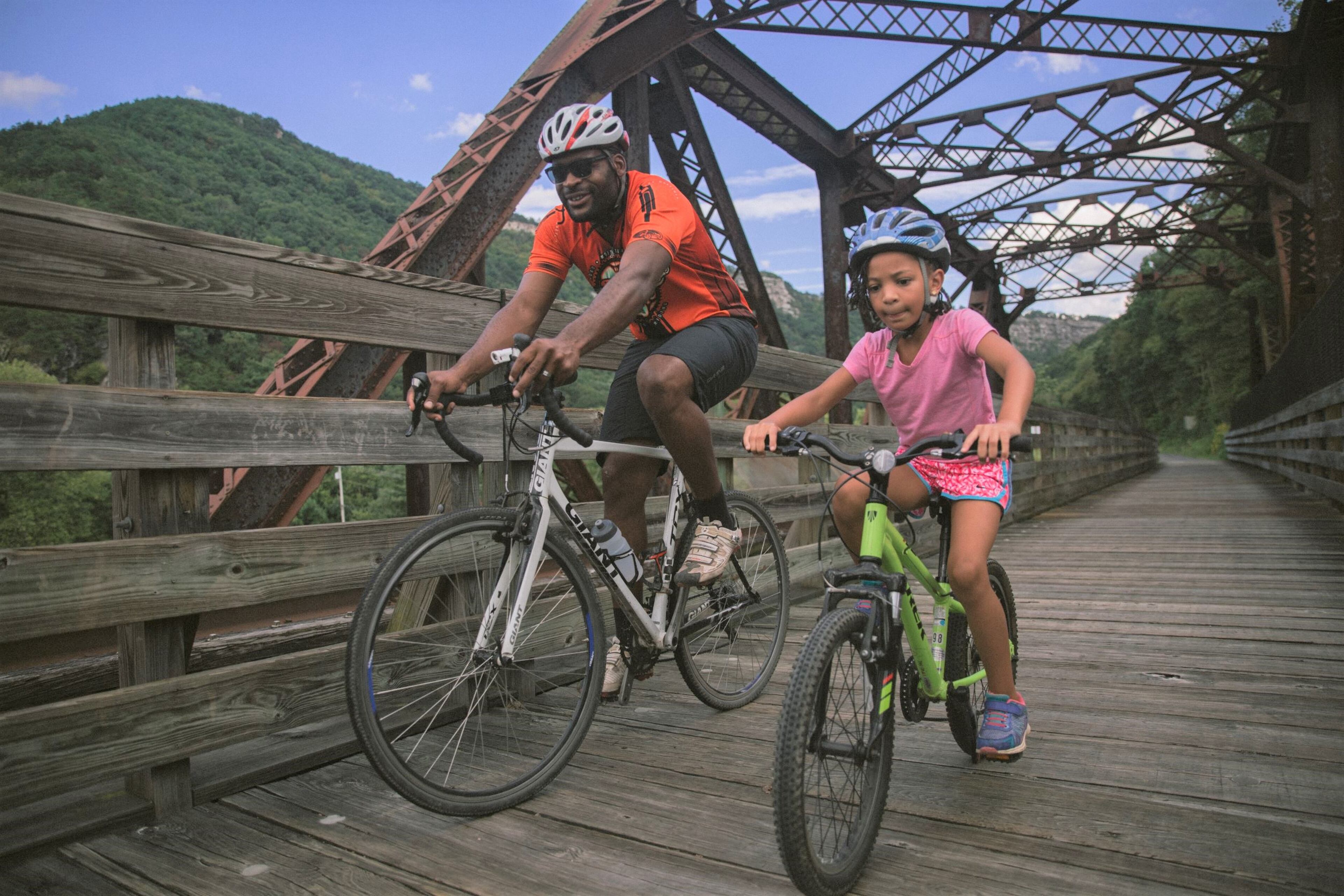 Owner of Wheelzup Adventures Mandela Echefu bikes the Great Alleghany Passage with his daughter near Cumberland, Maryland.
(Courtesy of mdmountainside.com)