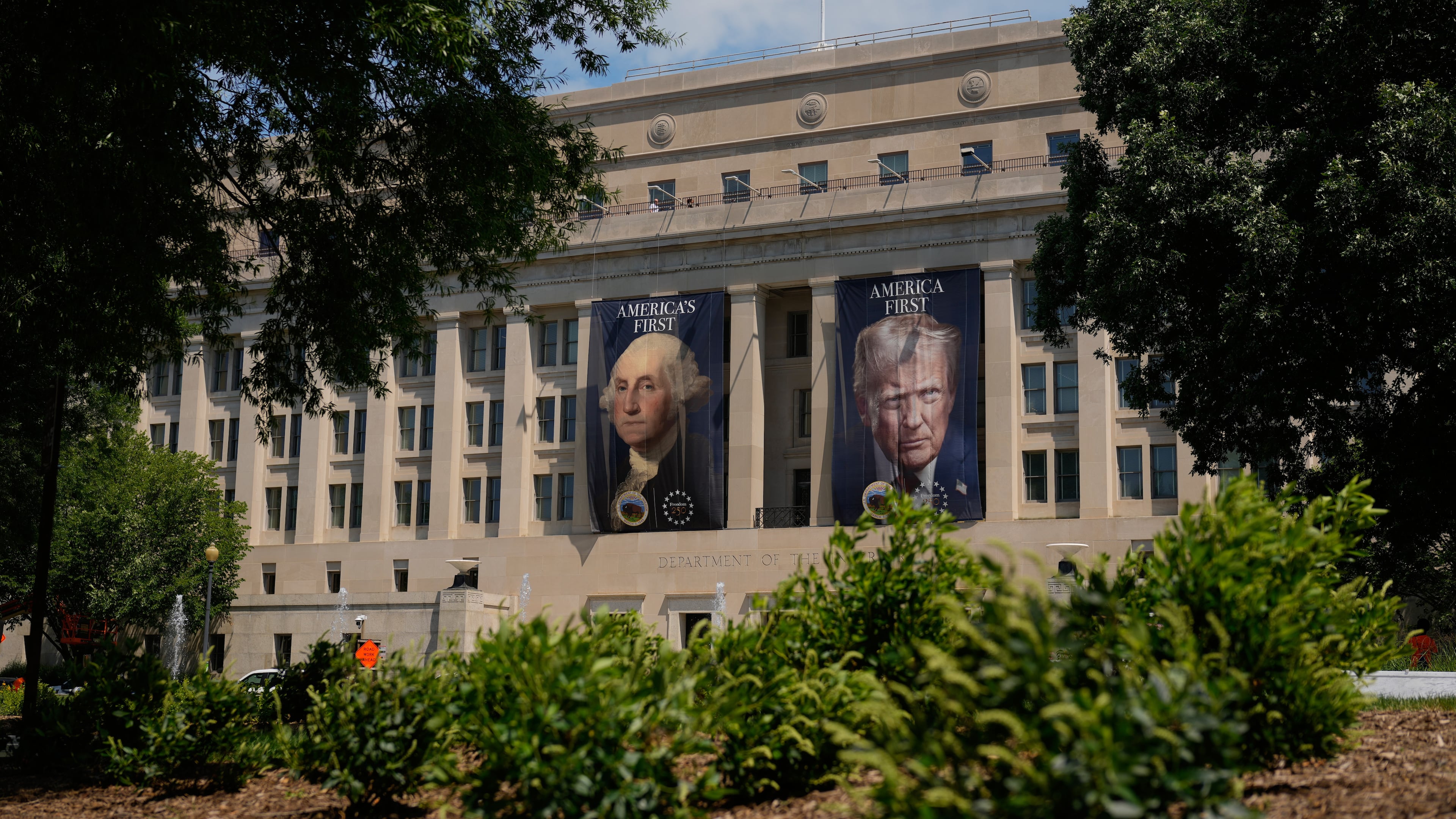 Banners of former President George Washington and President Donald Trump hang above an entrance to the Department of the Interior, Thursday, June 25, 2026, in Washington. (AP Photo/Carolyn Kaster)