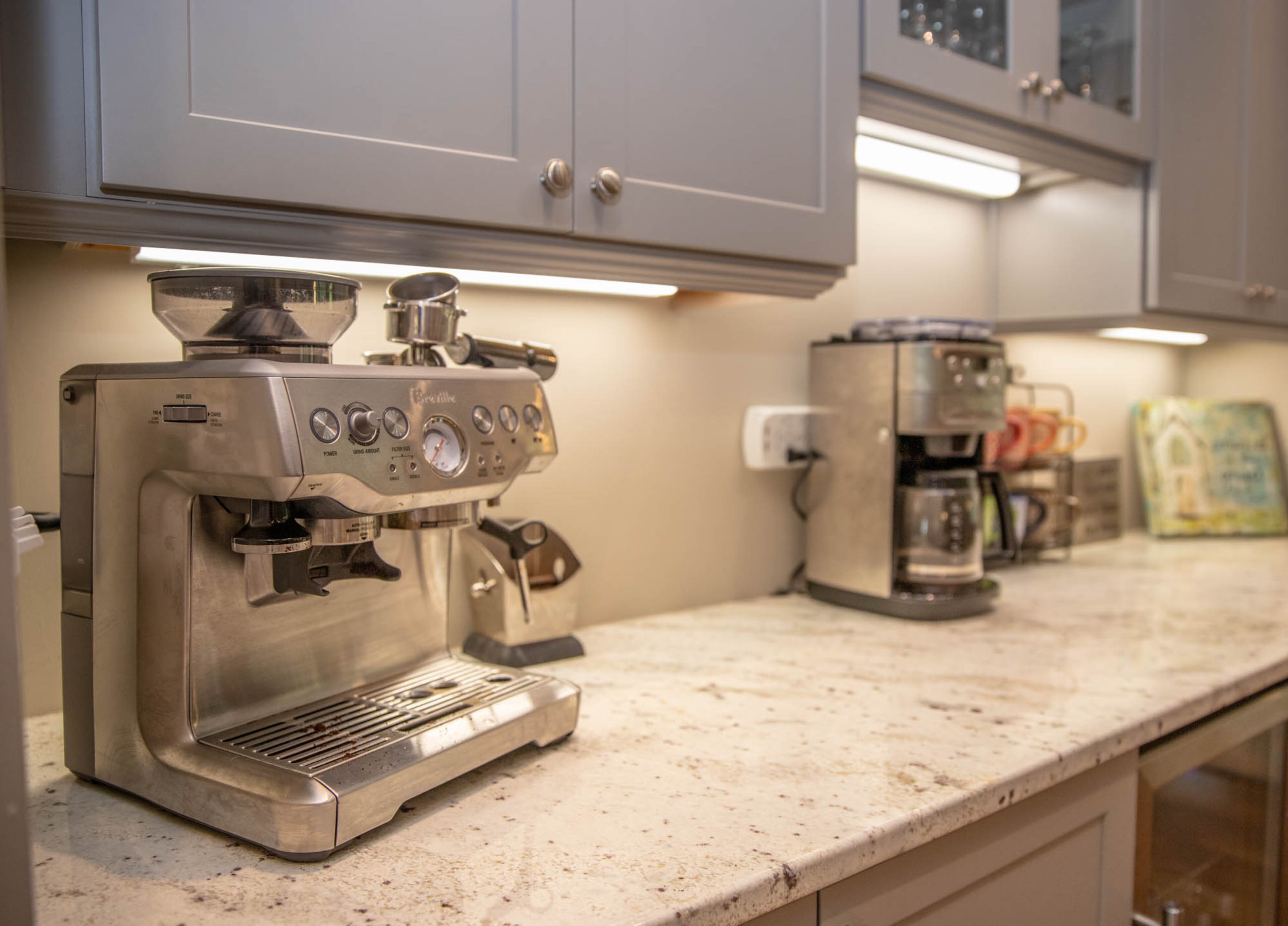 The coffee bar in Allie and Set Ott's home is transitional in style, bridging the gap between the more traditional kitchen and more contemporary living room. The coffee bar has Schrock cabinets by CSI Kitchen & Bath Studio and a counter of Andromeda Cream granite by Atlantis Granite & Marble. Text by Shannon Dominy. Photo by Reynolds Rogers.