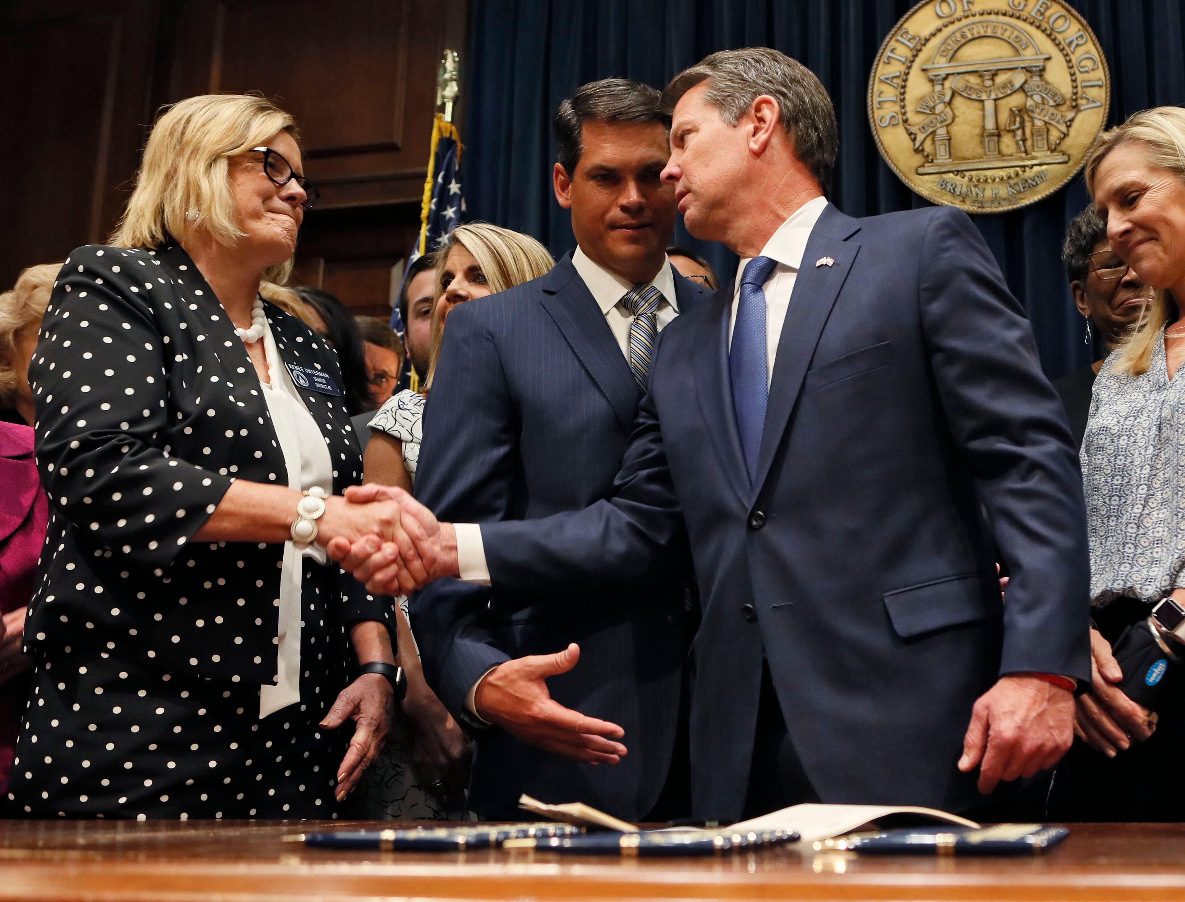 May 7, 2019 - Atlanta - After the signing, Gov. Brian Kemp congratulated Sen. Renee Unterman, R - Buford. Between them is Lt. Gov. Geoff Duncan. Kemp signed HB 481, the "heartbeat bill", on Tuesday, setting the stage for a legal battle as the state attempts to outlaw most abortions after about six weeks of pregnancy. The bill, sponsored by Rep. Ed Setlzer, R-Acworth, and carried in the Senate by Sen. Renee Unterman, R - Buford, outlaws most abortions once a doctor can detect a fetus' heartbeat - usually around six weeks of pregnancy. Bob Andres / bandres@ajc.com