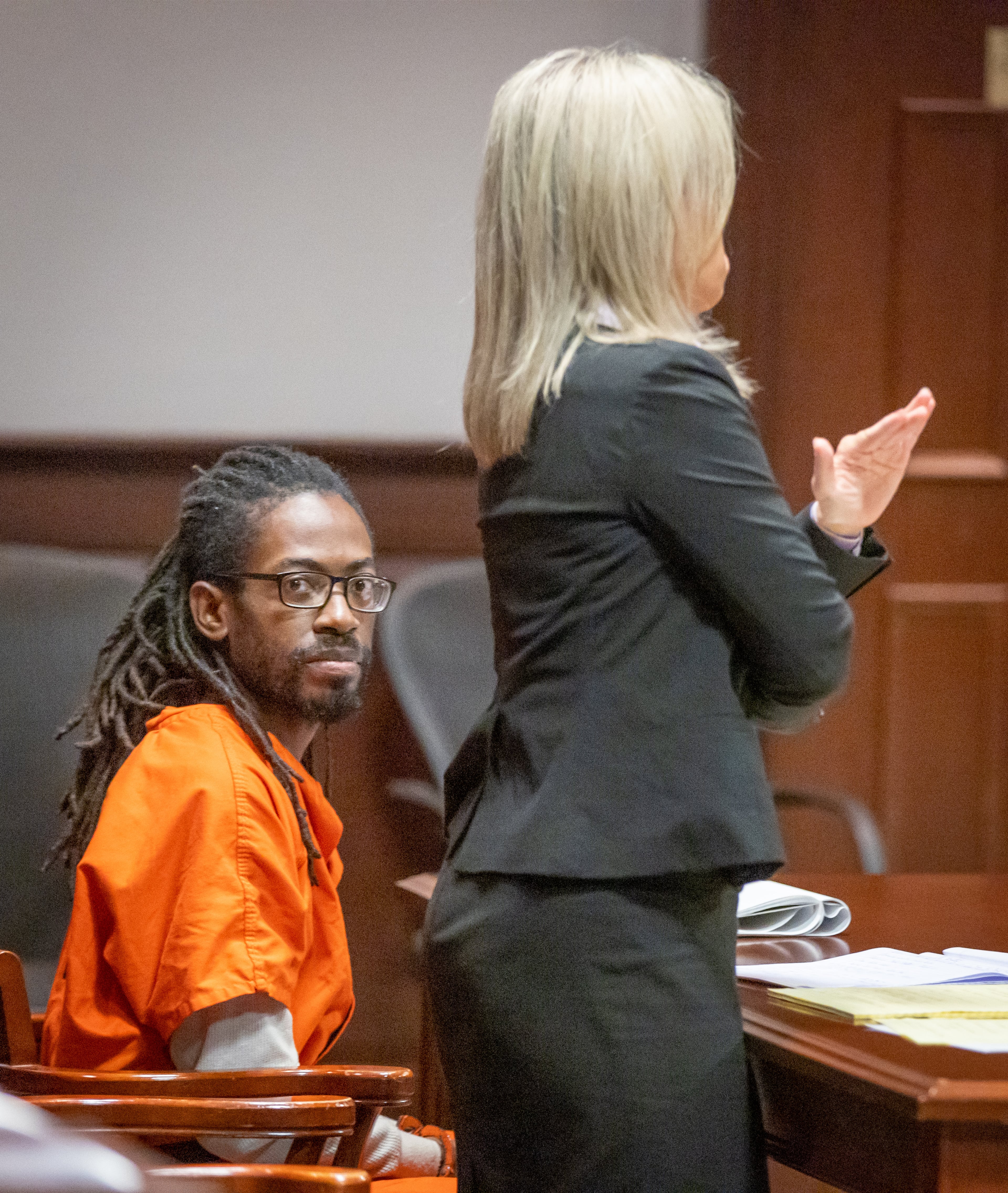 Black Hammer leader Augustus Claudius Romain Jr., 38, known as Gazi Kodzo, listens to his attorney Stacey Flynn talk to the judge during his hearing at the County Justice Center in Fayetteville on Wednesday, Aug. 17, 2022. The state dismissed charges against Romain earlier this week. (Steve Schaefer/AJC)