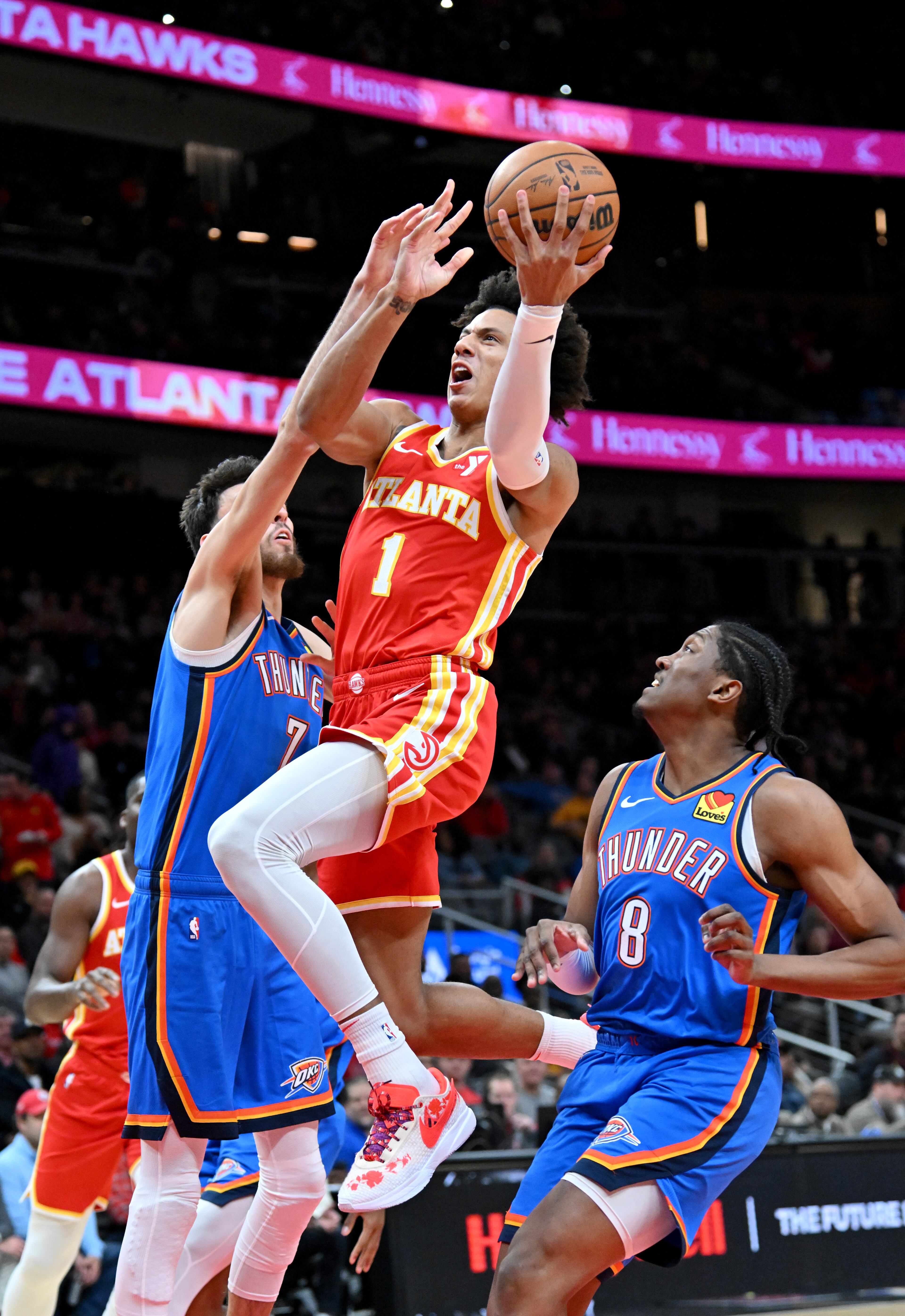 Atlanta Hawks forward Jalen Johnson (1) drives against Oklahoma City Thunder forward Chet Holmgren (7) during the first half in an NBA basketball game at State Farm Arena, Wednesday, December 3, 2024, in Atlanta. (Hyosub Shin / Hyosub.Shin@ajc.com)