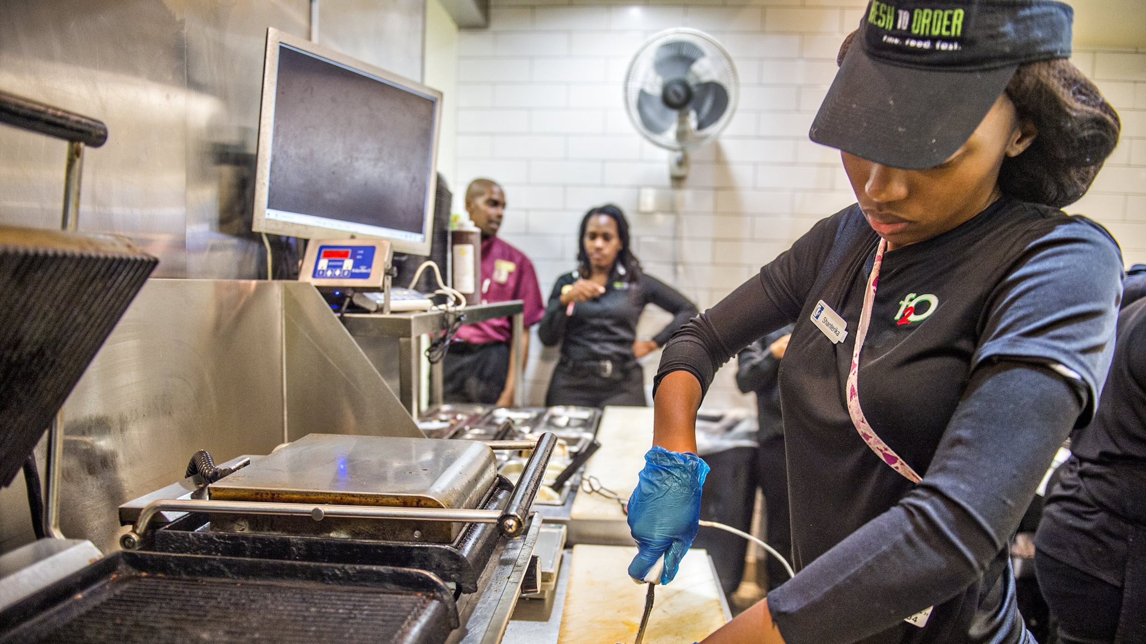 Shanterika Shealey uses a tethered knife to cut a sandwich at Fresh to Order at Hartsfield-Jackson International Airport. JONATHAN PHILLIPS / SPECIAL
