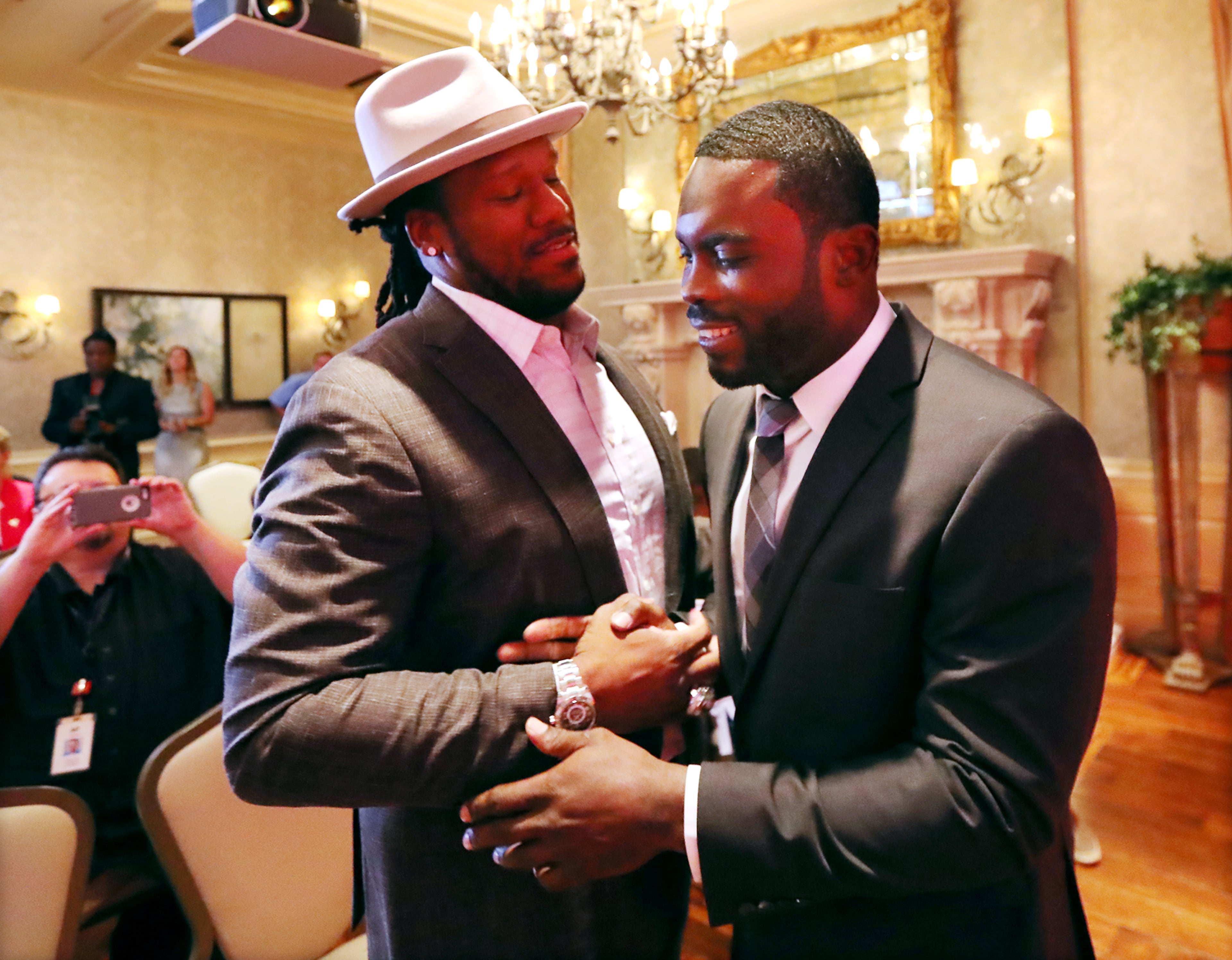Veteran defensive tackle Jonathan Babineaux greets former Falcons quarterback Michael Vick as he arrives to be honored by the Falcons officially retiring from the NFL on Monday, June 12, 2017, in Atlanta.