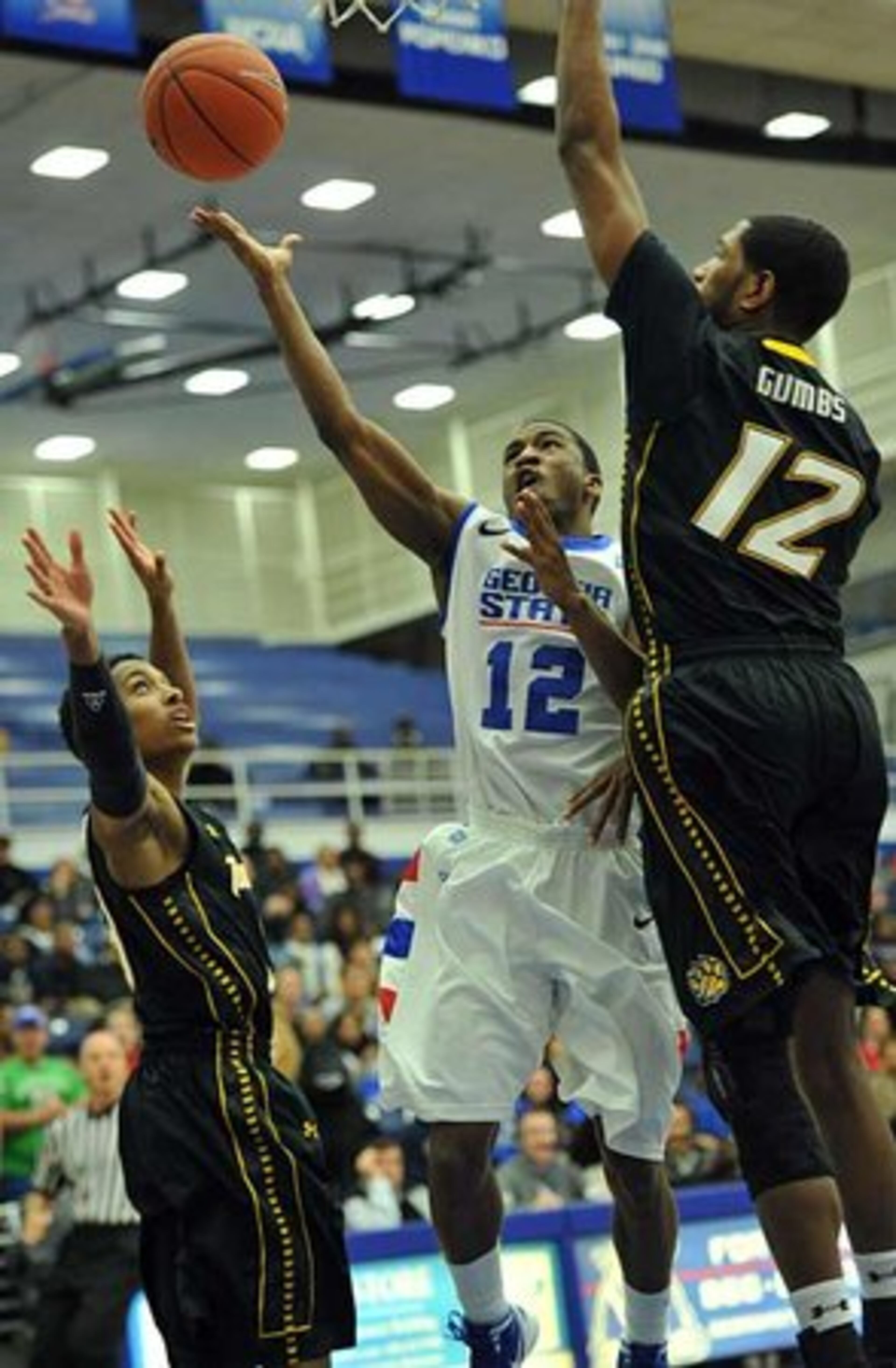 Georgia State guard Devonta White shoots between Towson guard Kris Walden (left) and Towson forward Erique Gumbs.