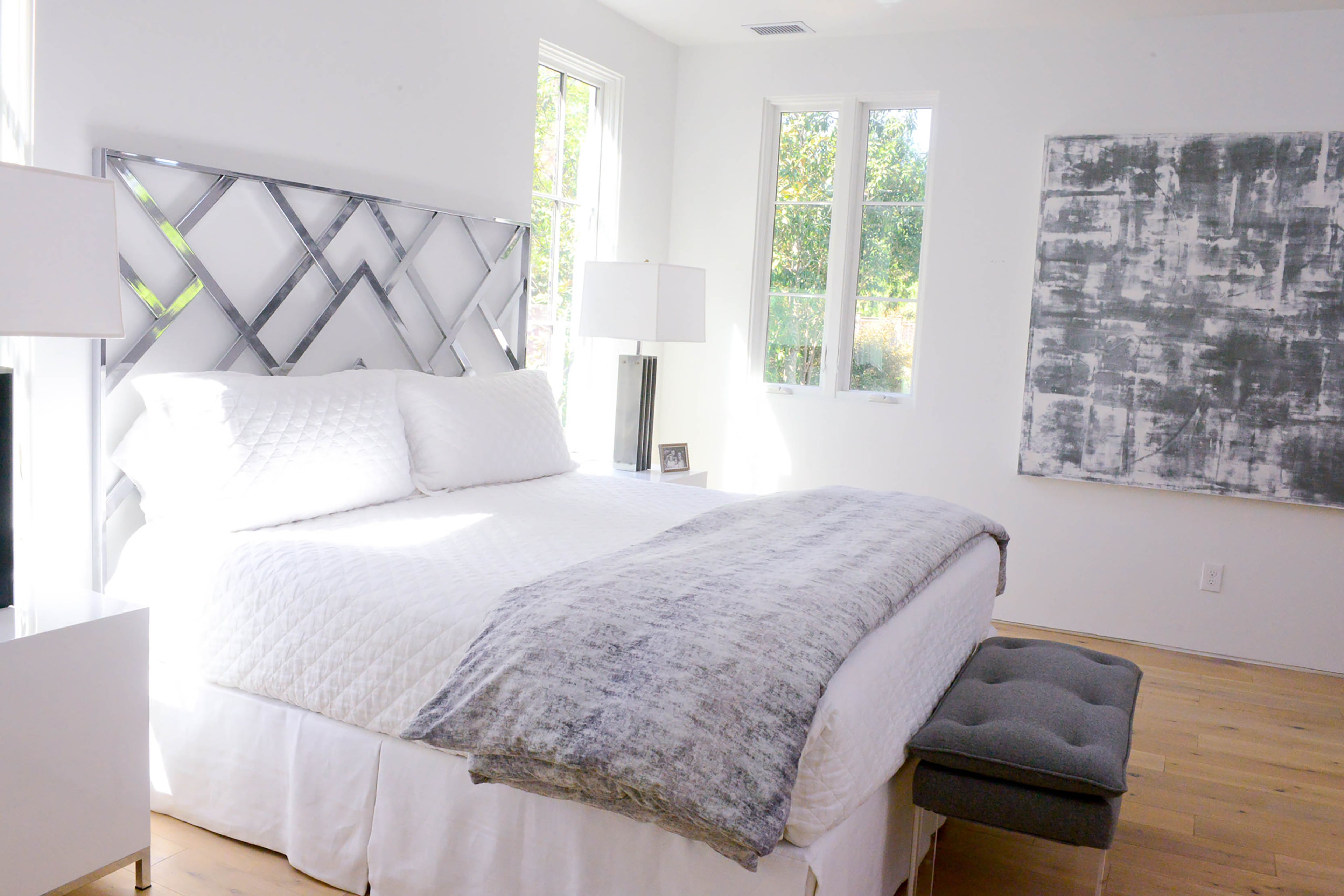 A metal Milo Baughman headboard, from Westside Market, shines against the pure white walls in Caroline and Paul Normark's master bedroom. Throughout the renovated home, the couple opted for simple, clean lines, along with no trim and plenty of natural light to create an interior that is a blend of modern, minimalist and Scandinavian styles.