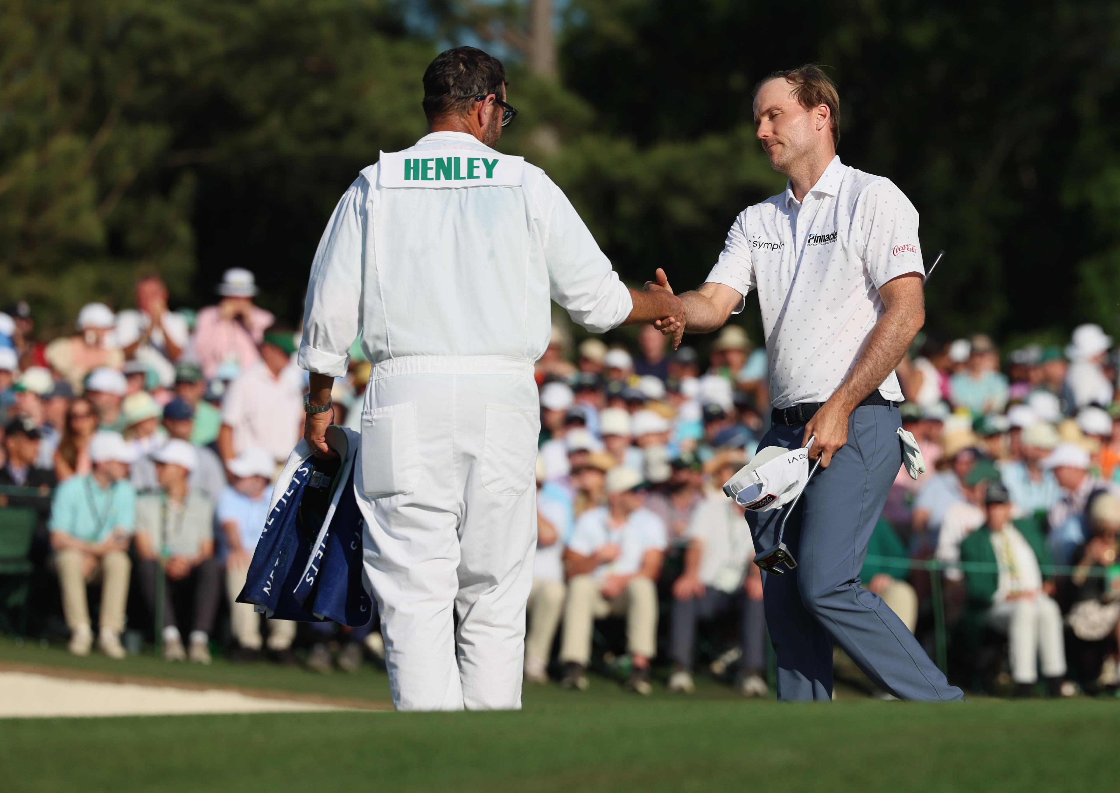 Russell Henley greets his caddie Andrew Sanders at the end of final round of the Masters, at Augusta National Golf Club, Sunday, April 12, 2026, in Augusta, GA (Jason Getz/AJC)