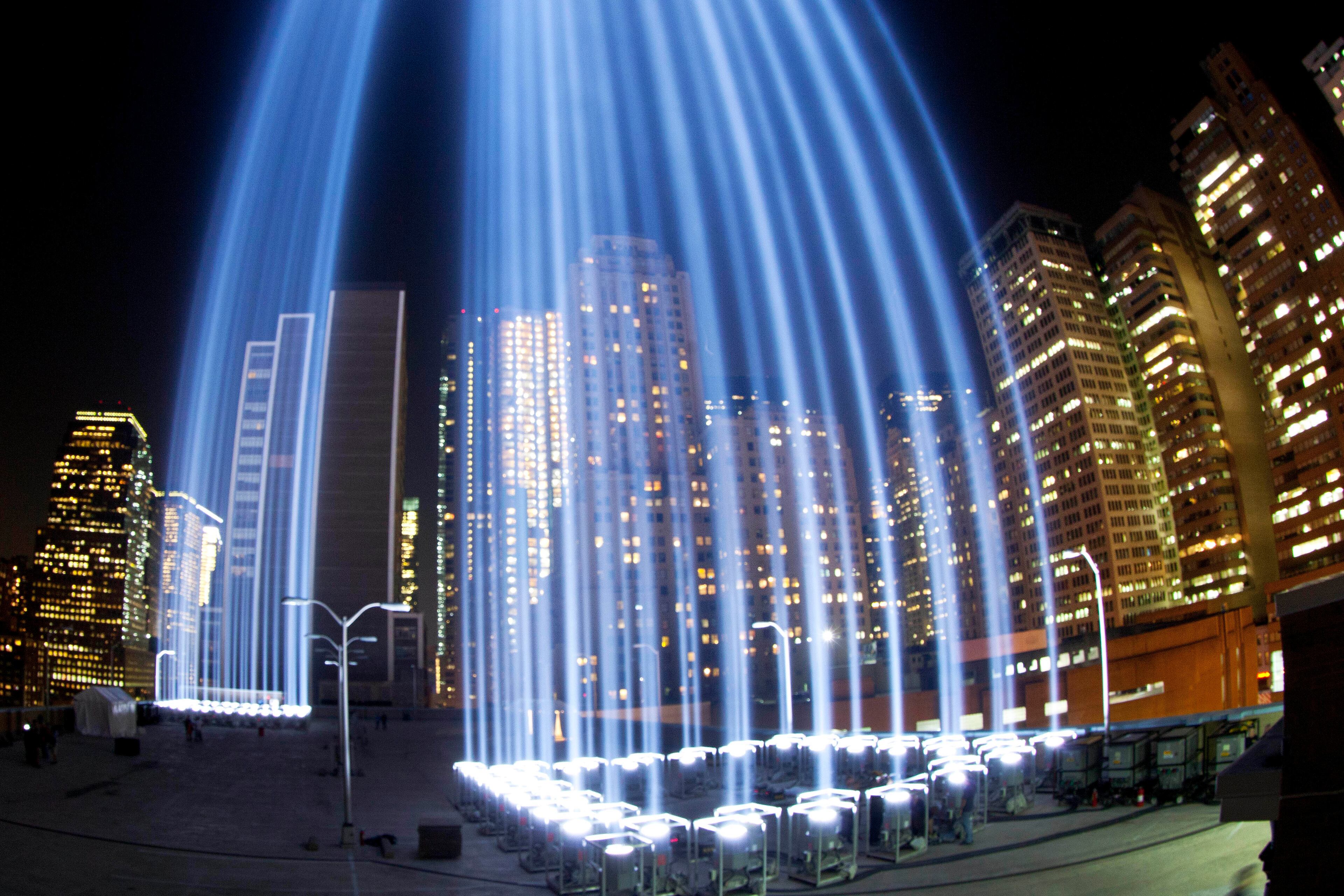 In a photo made with a fisheye lens, the Tribute in Light rises above buildings in lower Manhattan, during a test, Tuesday, Sept. 10, 2013 in New York. The light display commemorates the twin towers of the World Trade Center that were destroyed in terrorist attacks 12 years ago on Sept. 11, 2001. (AP Photo/Mark Lennihan)