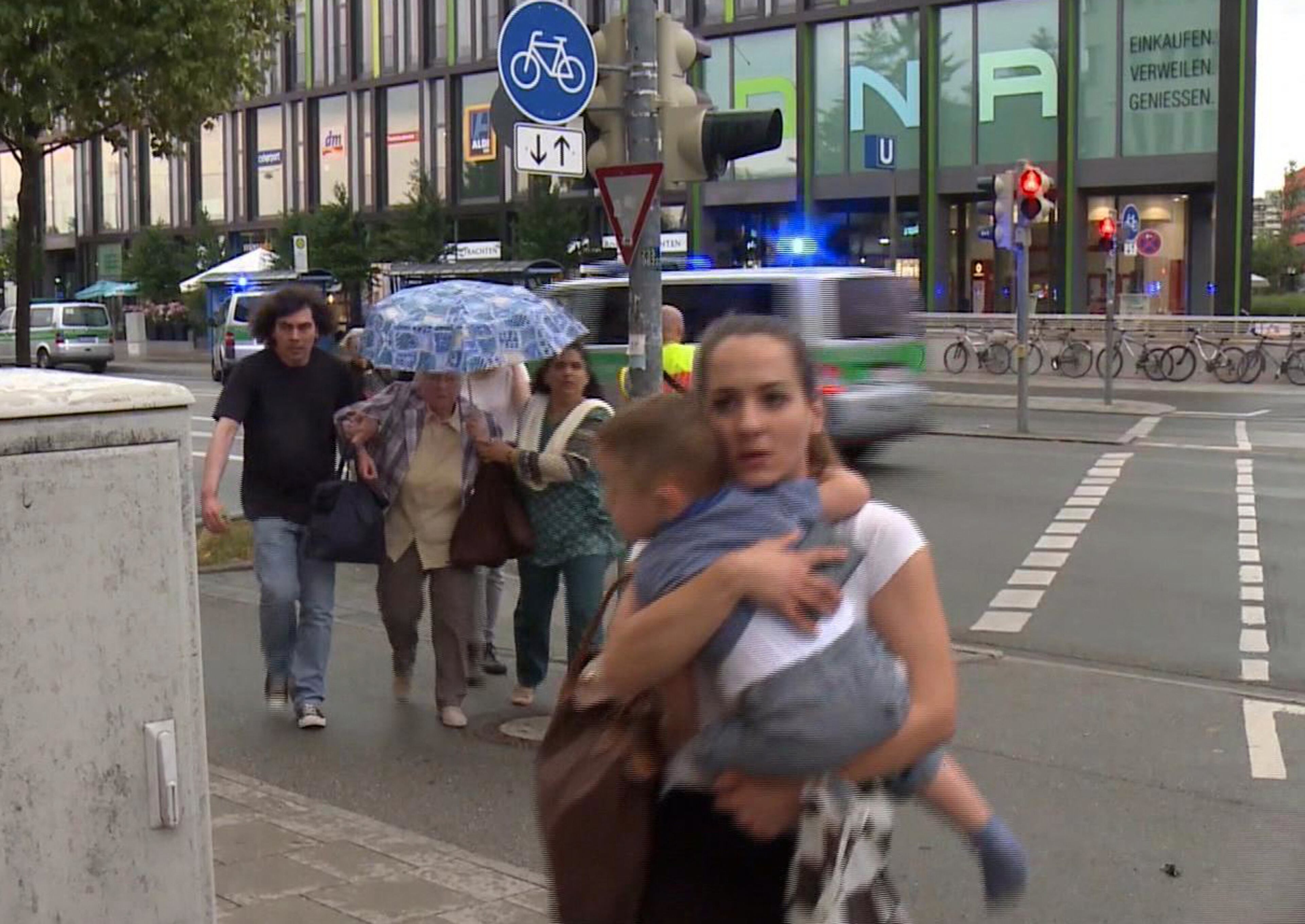 Members of the public run away from the Olympia Einkaufszentrum mall, after a shooting, in Munich, Germany, Friday, July 22, 2016. The city transit system shut down and police asked people to avoid public places. (AP)
