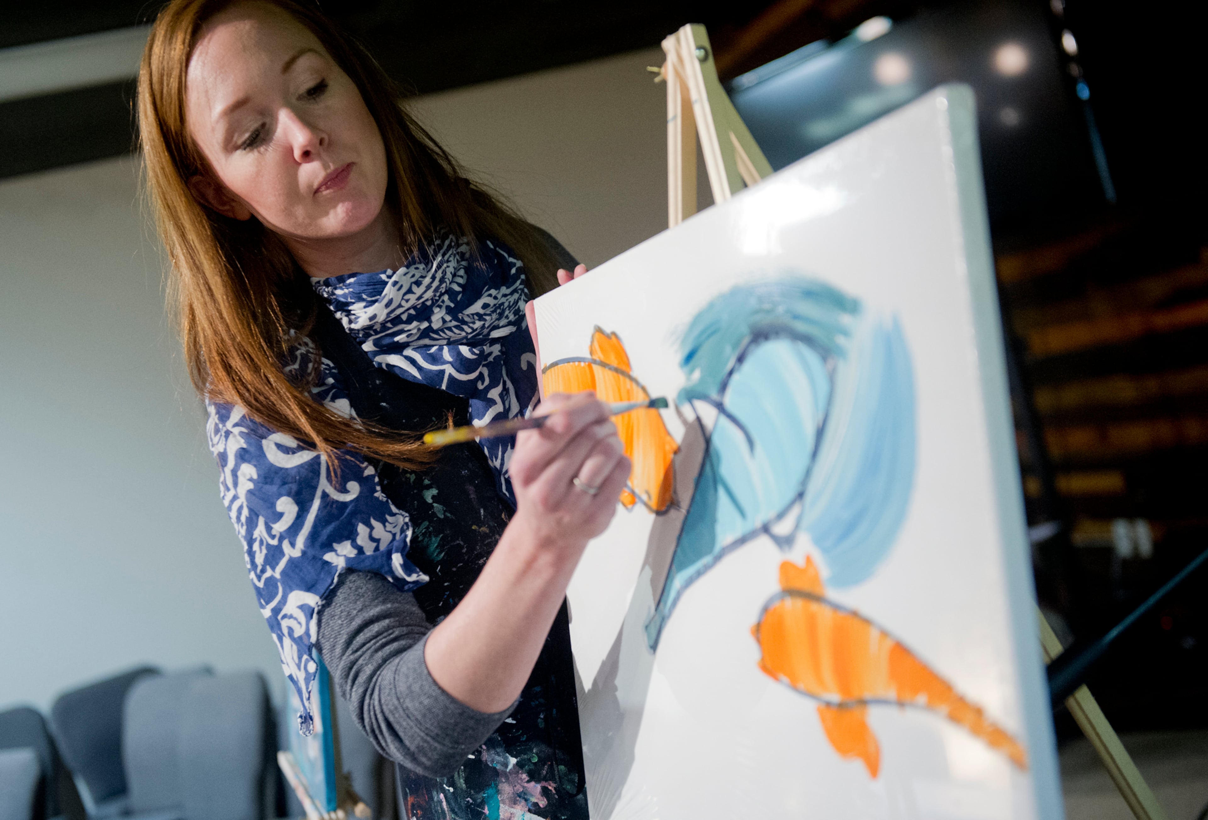 Kate Saville Hawkins (left) explains the next step to painting sharks and koi fish. JONATHAN PHILLIPS / SPECIAL