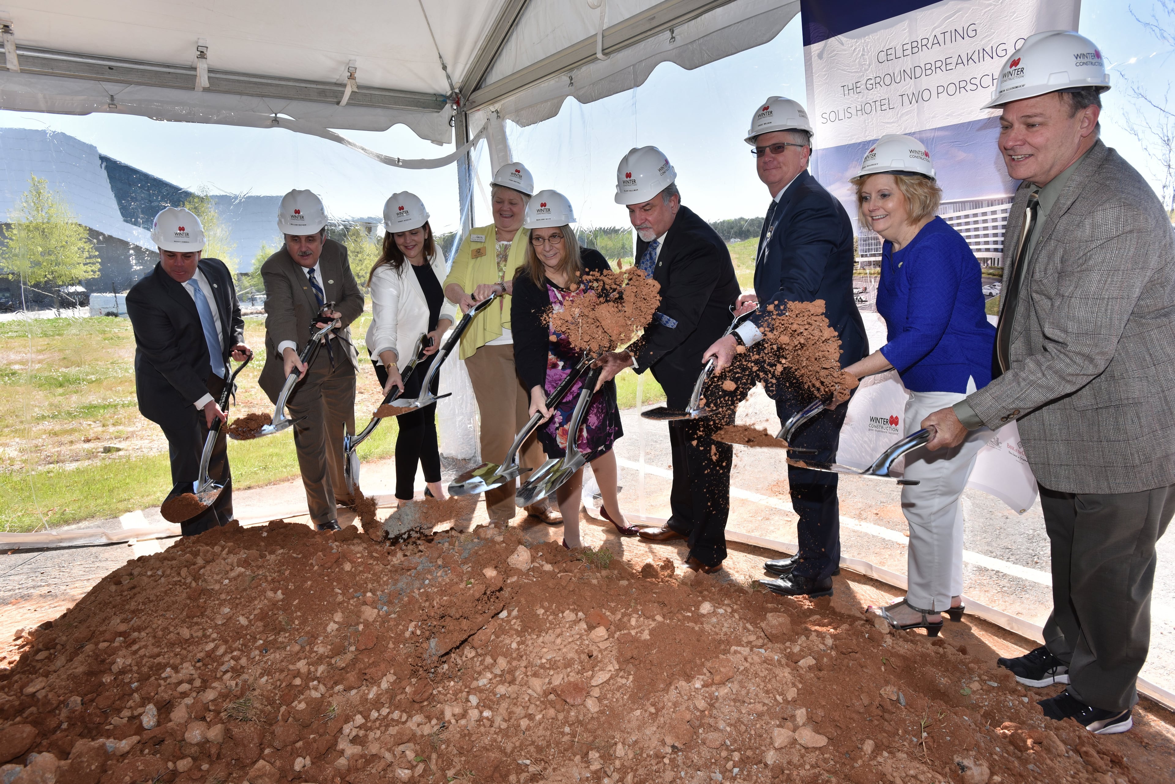 With the Porsche Experience Center in the background, Hapeville Mayor Alan Hallman (6th from left) and other city officials participate in a ceremonial groundbreaking for Solis Hotel. Southside businesses, political and community leaders have long-held onto the idea that the airport area could become a thriving business district like Buckhead or Perimeter.