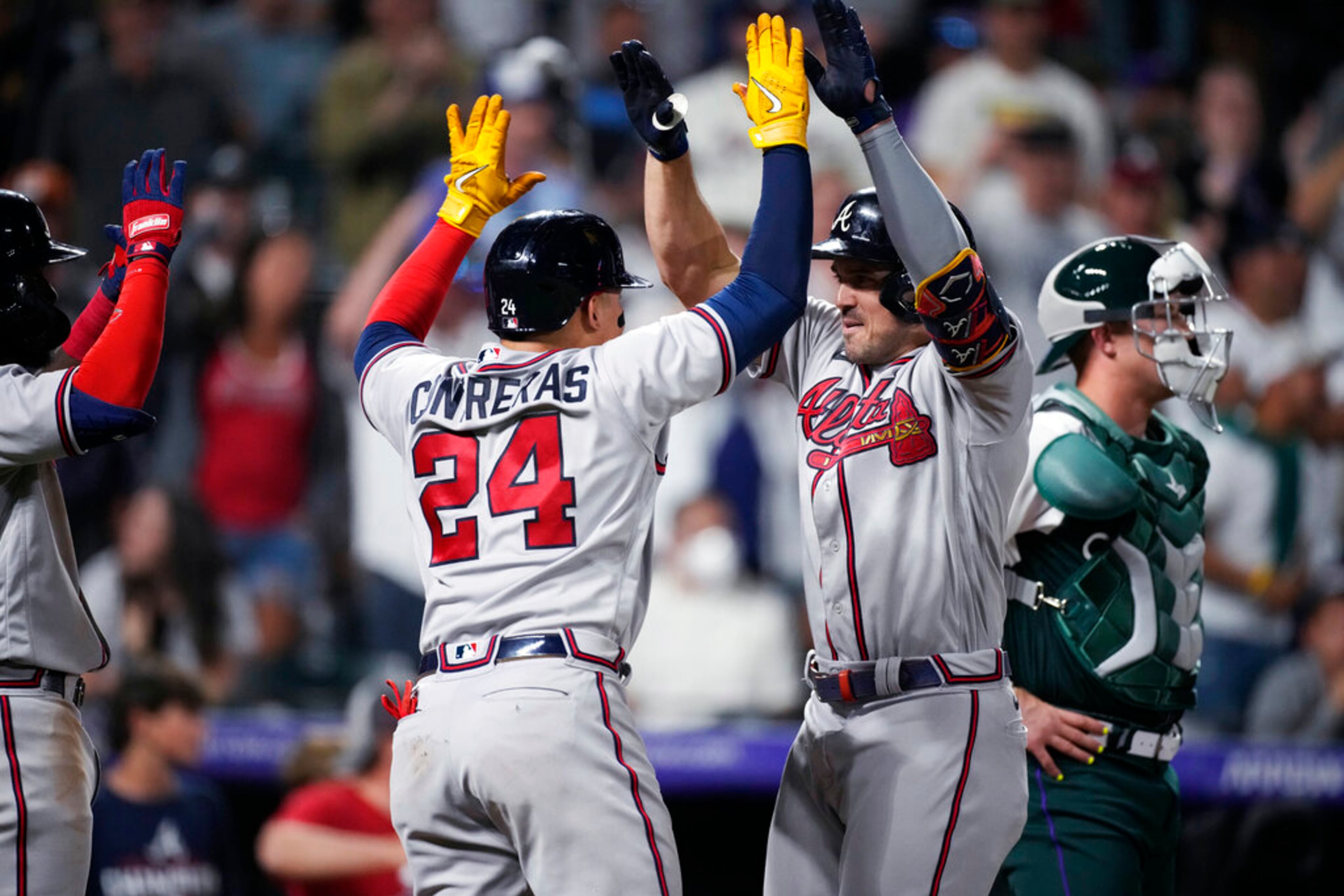 Atlanta Braves' William Contreras, left, congratulates Adam Duvall, who had hit a two-run home run, near Colorado Rockies catcher Brian Serven during the 11th inning of a baseball game Saturday, June 4, 2022, in Denver. The Braves won 6-2. (AP Photo/David Zalubowski)
