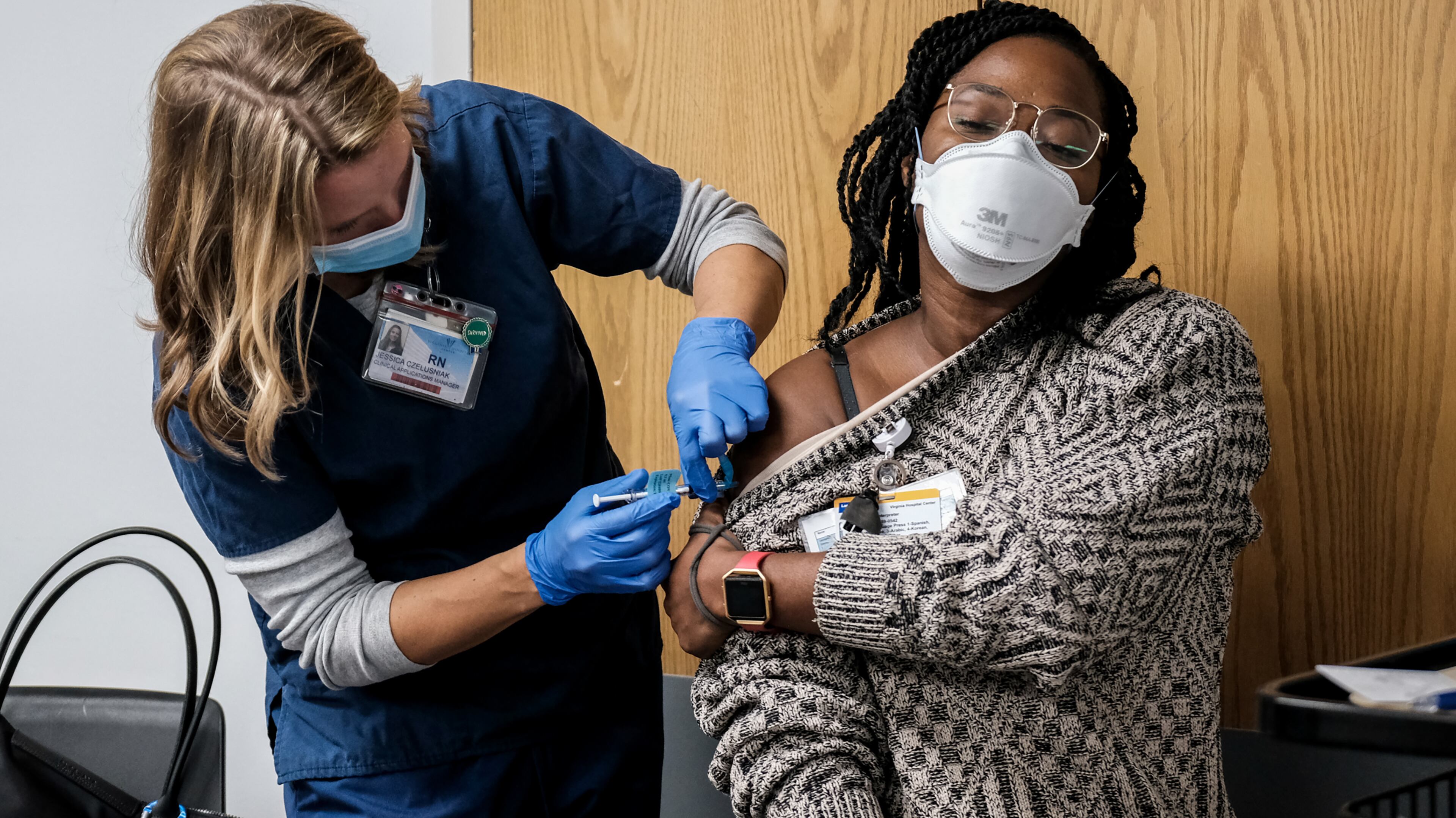 A health care worker receives a Pfizer-BioNTech COVID-19 vaccine at Virginia Hospital Center in Arlington, Va., on Wednesday, Dec. 16, 2020. Since even the first shot appears to provide some protection against COVID-19, some experts believe that the shortest route to containing the virus is to disseminate the initial injections as widely as possible now. (Michael A. McCoy/The New York Times)