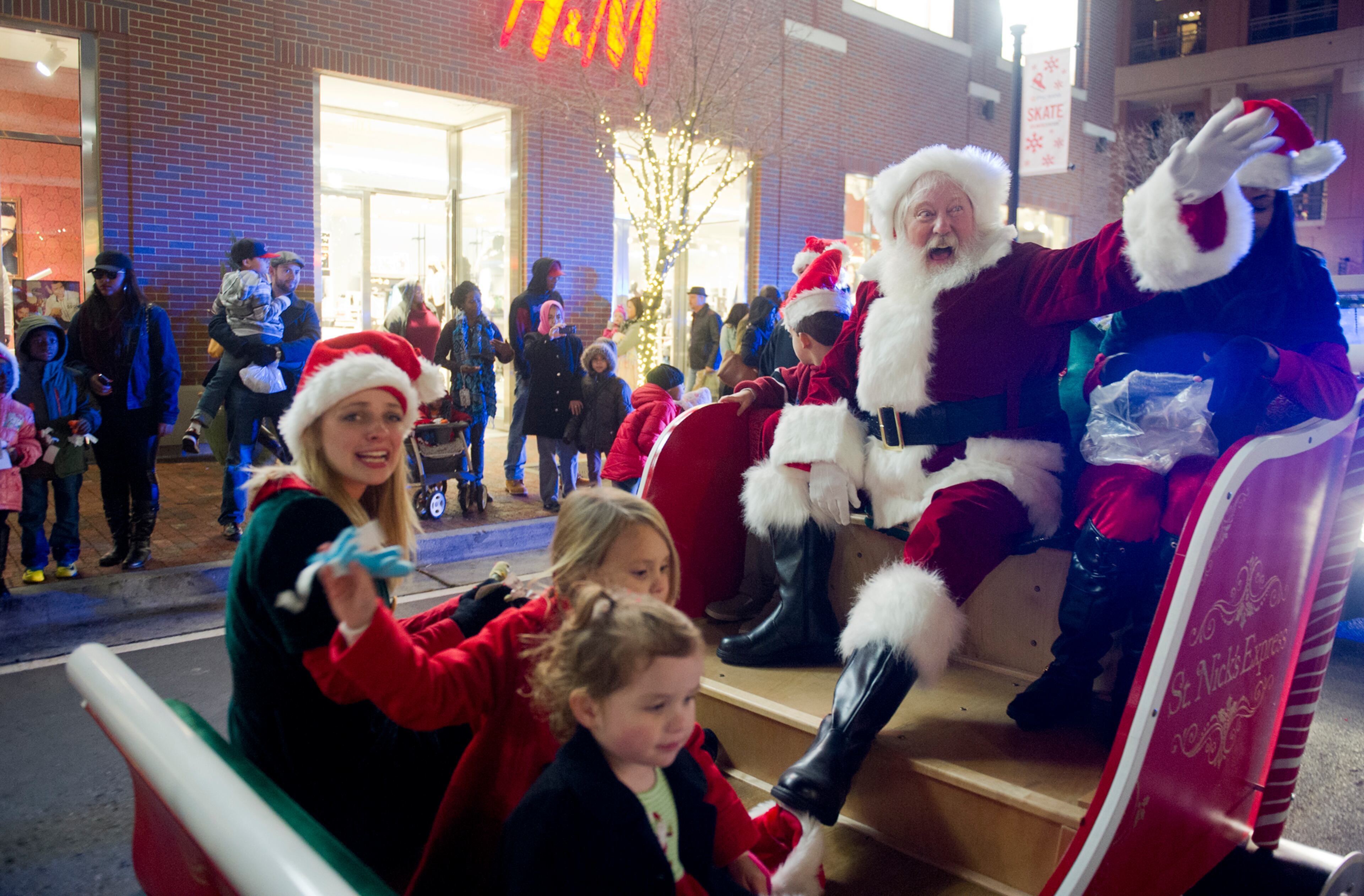 Santa Claus waves to the crowd while in his sleigh for the parade at Atlantic Station in Atlanta during the annual Christmas tree lighting on Nov. 23, 2013.