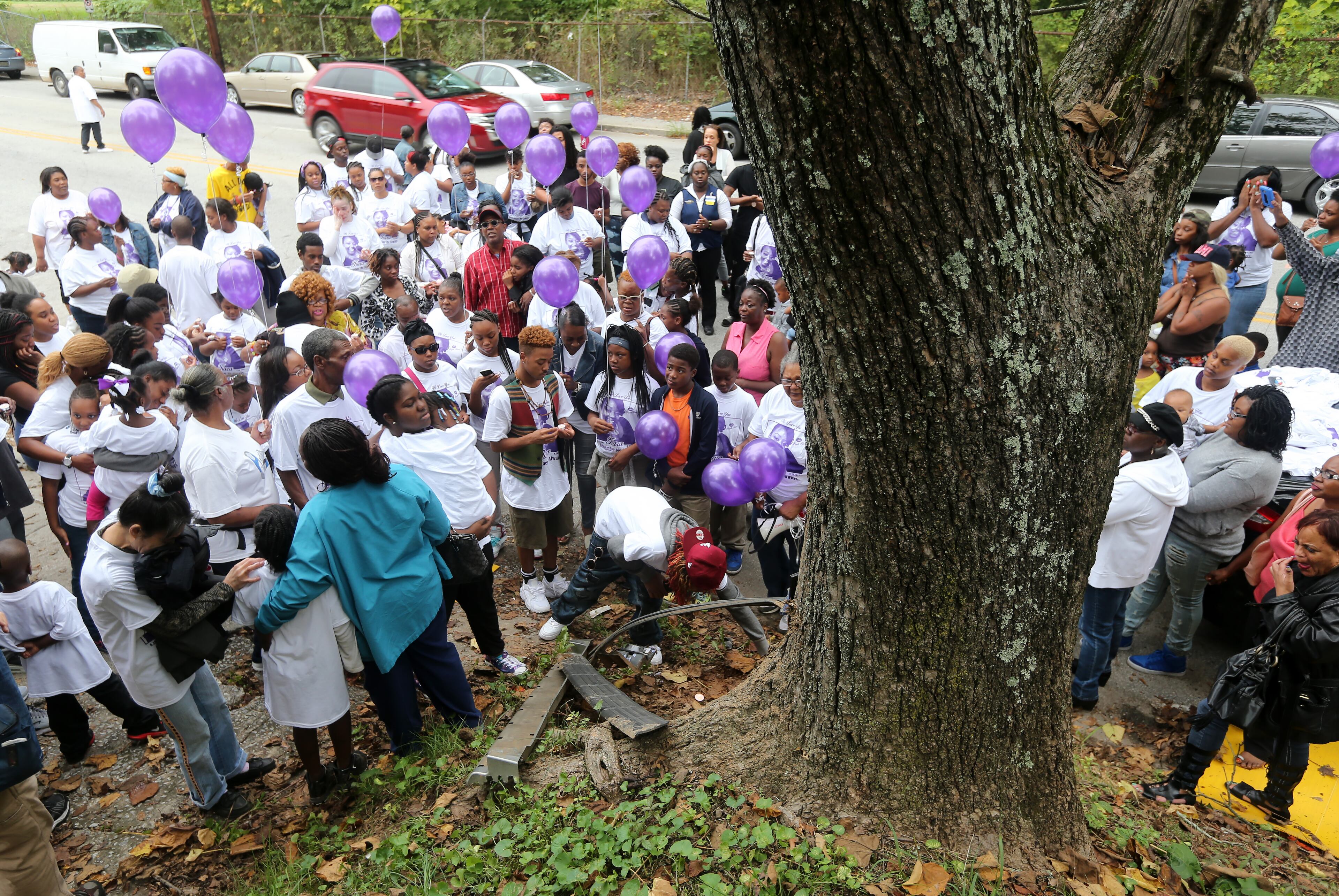Mourners gather around a tree near where Tiara Bogan Jones, a 25-year-old mother of two, was shot and killed early Saturday morning in southeast Atlanta. The memorial was set up during a vigil held Thursday evening, Oct. 1, 2015. Ben Gray / bgray@ajc.com