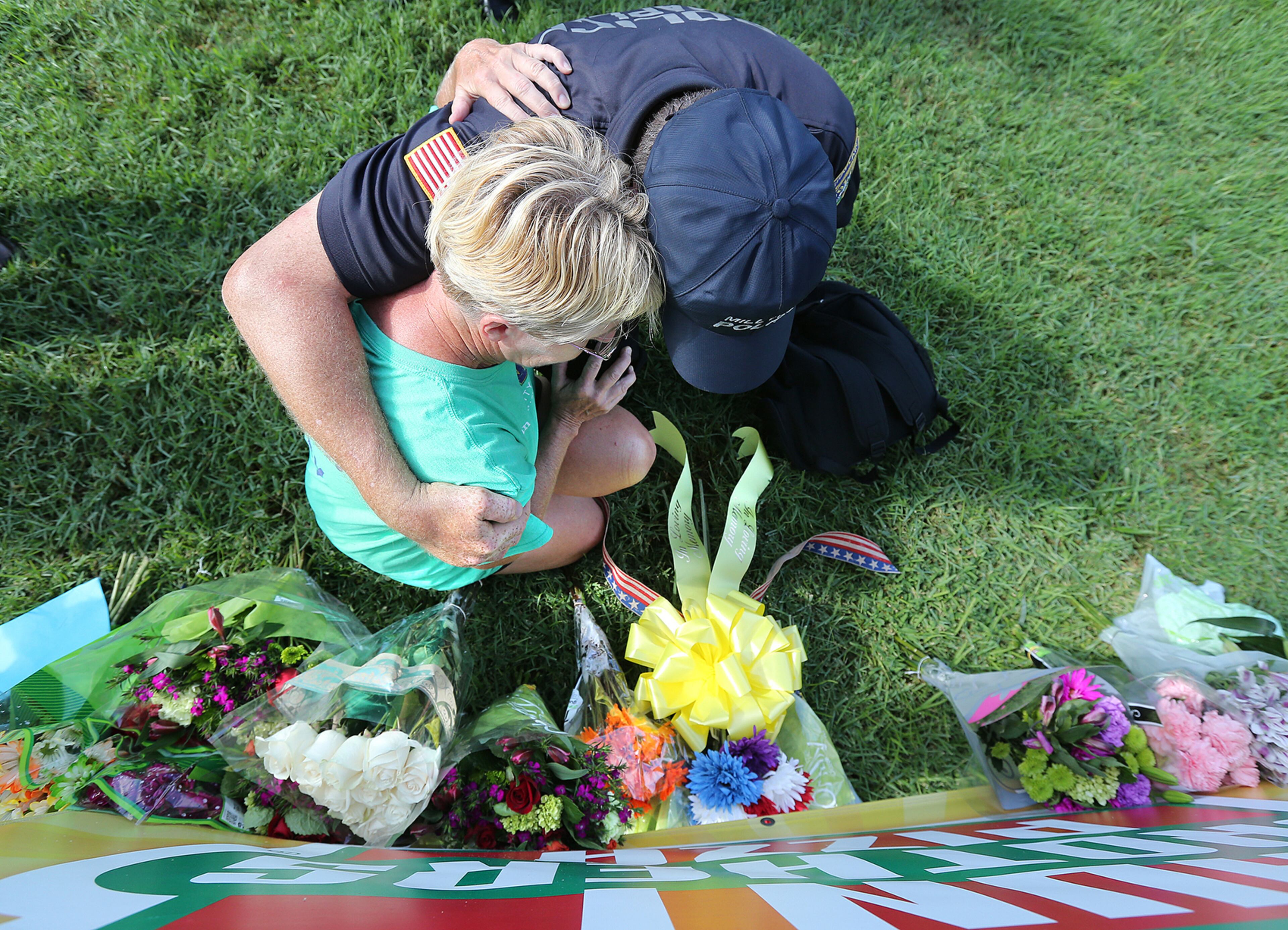 071816 BATON ROUGE: Millville Police Chaplain Bob Ossler prays and weeps with a local resident as she places flowers on a shrine at the B-Quik gas station on Monday, July 18, 2016, in Baton Rouge, a day after three police officers were killed and three others wounded at the scene. Ossler said it was “a very tender moment. Like myself she is hurting and we wept together. I told her the officers said we are ready. We are strong. They are going to make sure you are o.k.†Curtis Compton /ccompton@ajc.com