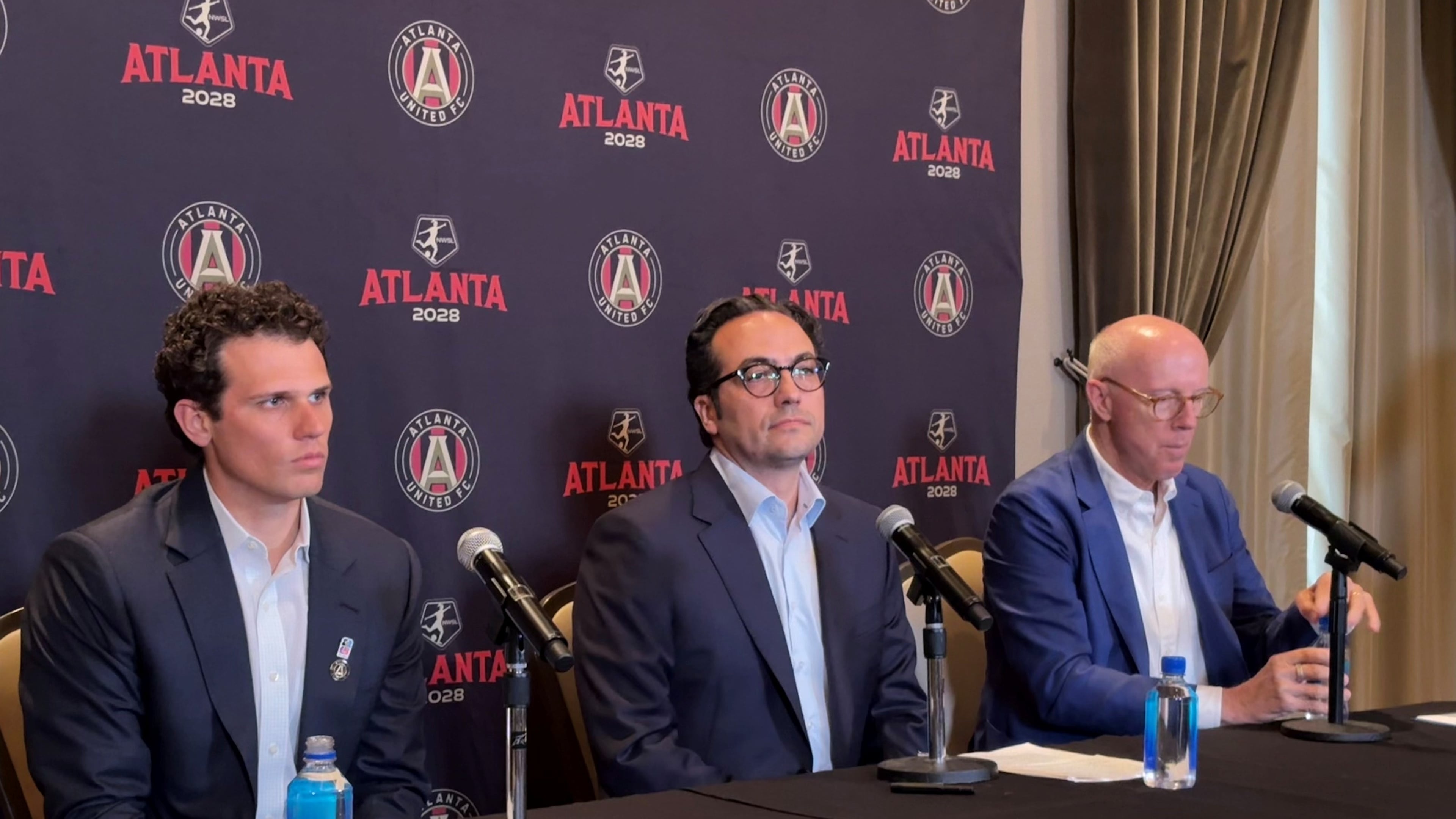 Mauricio Culebro (center), the president of soccer for Atlanta United and the city's upcoming NWSL franchise, answers questions at his introductory press conference. Josh Blank (left), vice president of executive for AMBSE, and Rich McKay (right), CEO of AMBSE, also took part. (Amna Subhan/AJC)