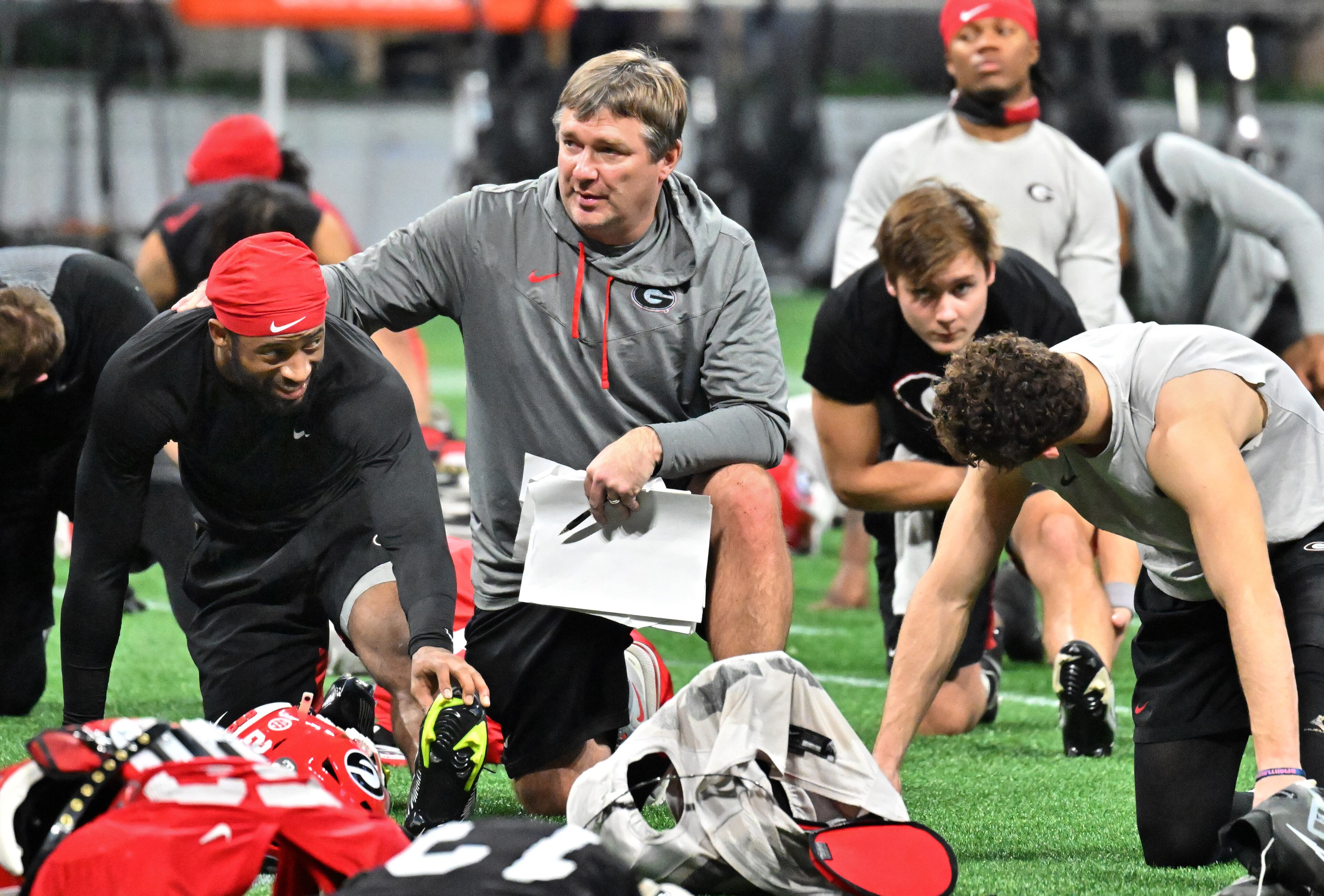 Georgia's head coach Kirby Smart speaks to defensive back Chris Smith as players stretch during a practice session for the Chick-fil-A Peach Bowl game against Ohio State at the Mercedes-Benz Stadium on Thursday, Dec. 29, 2022, in Atlanta. (Hyosub Shin / Hyosub.Shin@ajc.com)