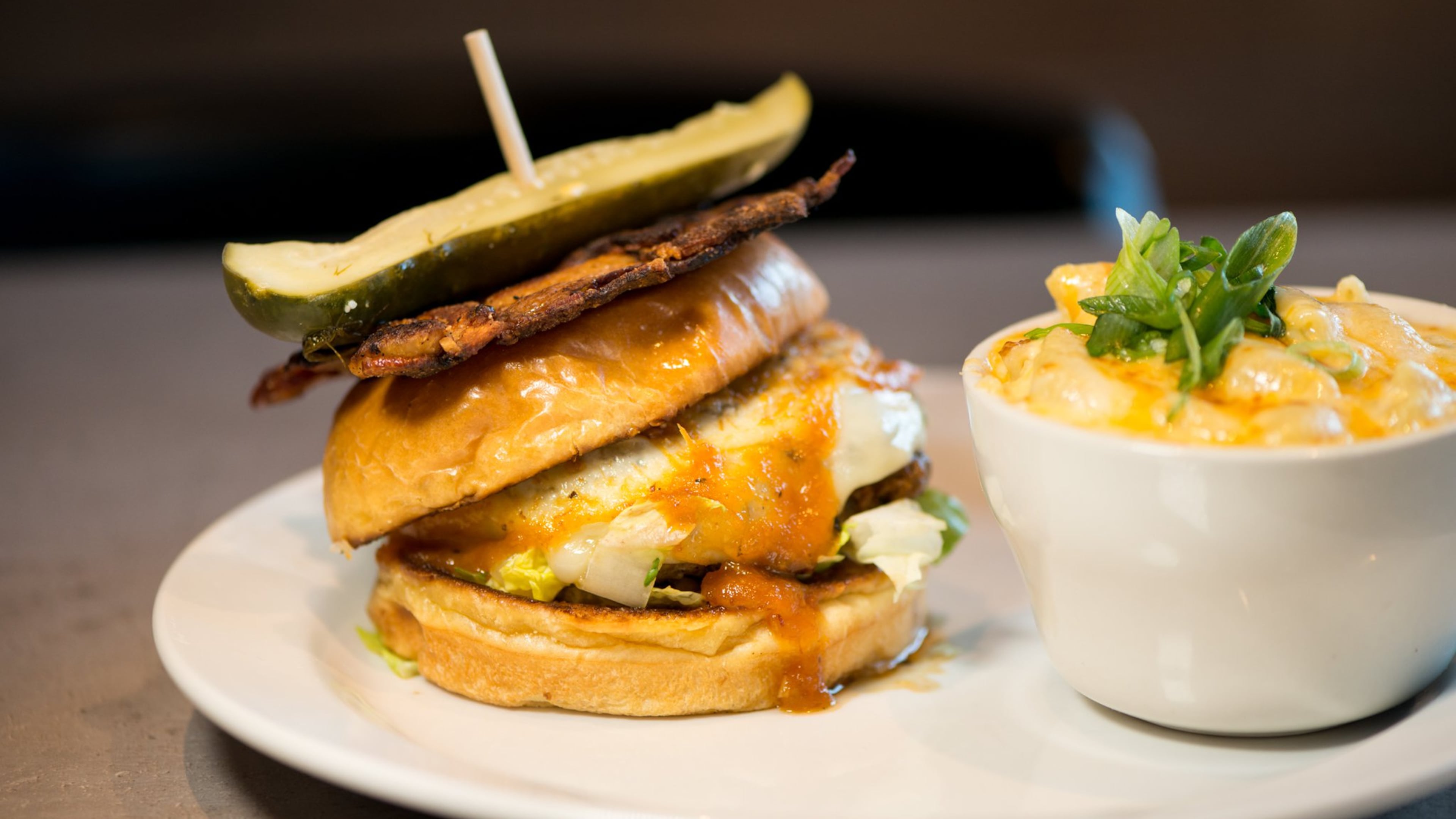 Hoyle's Kitchen and Bar signature Hoyle's Burger with lettuce, caramelized onion, woven bacon, provolone, and tomato jam. Photo credit- Mia Yakel.