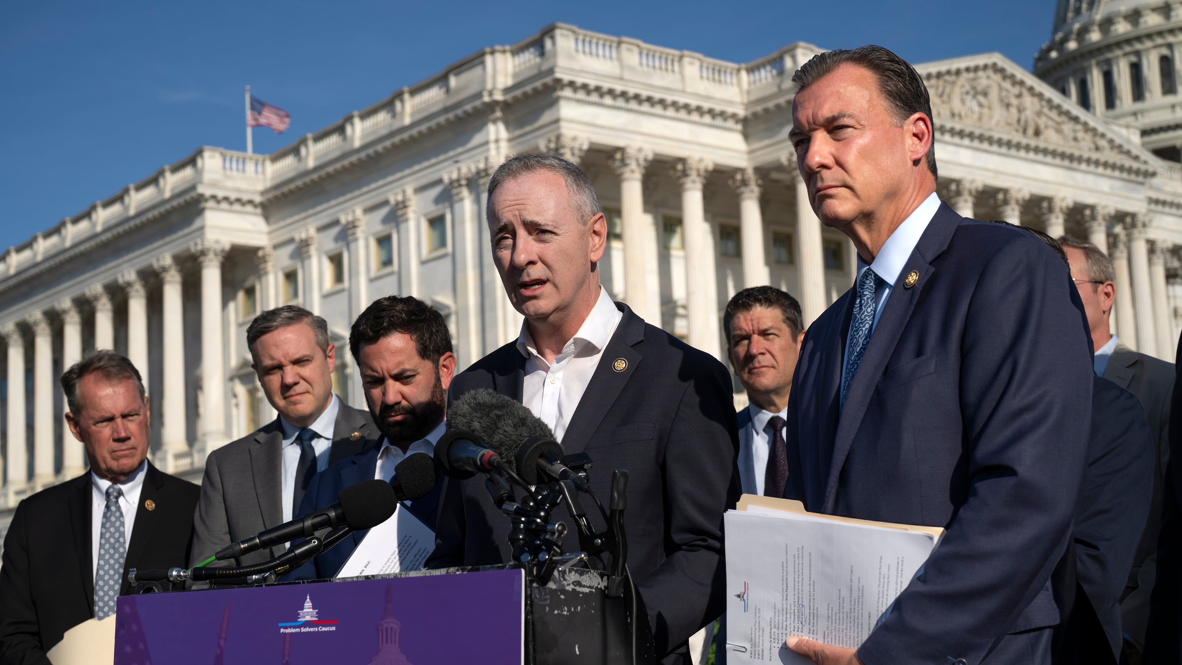 Rep. Brian Fitzpatrick, R-Pa., center, and Rep. Tom Suozzi, D-N.Y., right, talk to reporters about partisan gerrymandering, the reshaping of congressional districts to benefit one political party, during a news conference at the Capitol in Washington, Wednesday, Sept. 16, 2026. (AP Photo/J. Scott Applewhite)