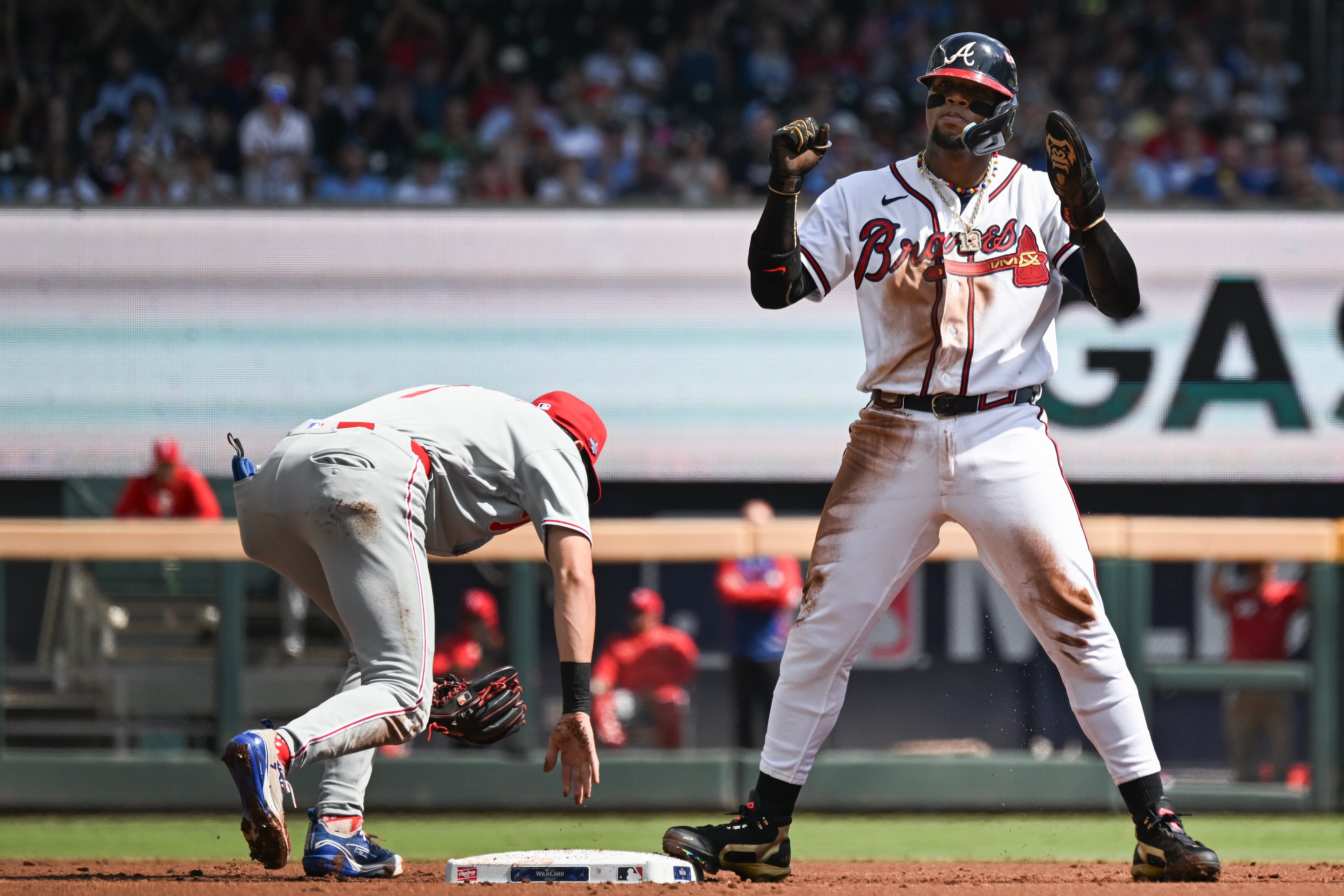Braves right fielder Ronald Acuña Jr. (right) celebrates after stealing second base against Phillies shortstop Trea Turner during Game 2 of their NL Wild Card Series on Wednesday, Sept. 30, 2026, in Atlanta. (Hyosub Shin/AJC)