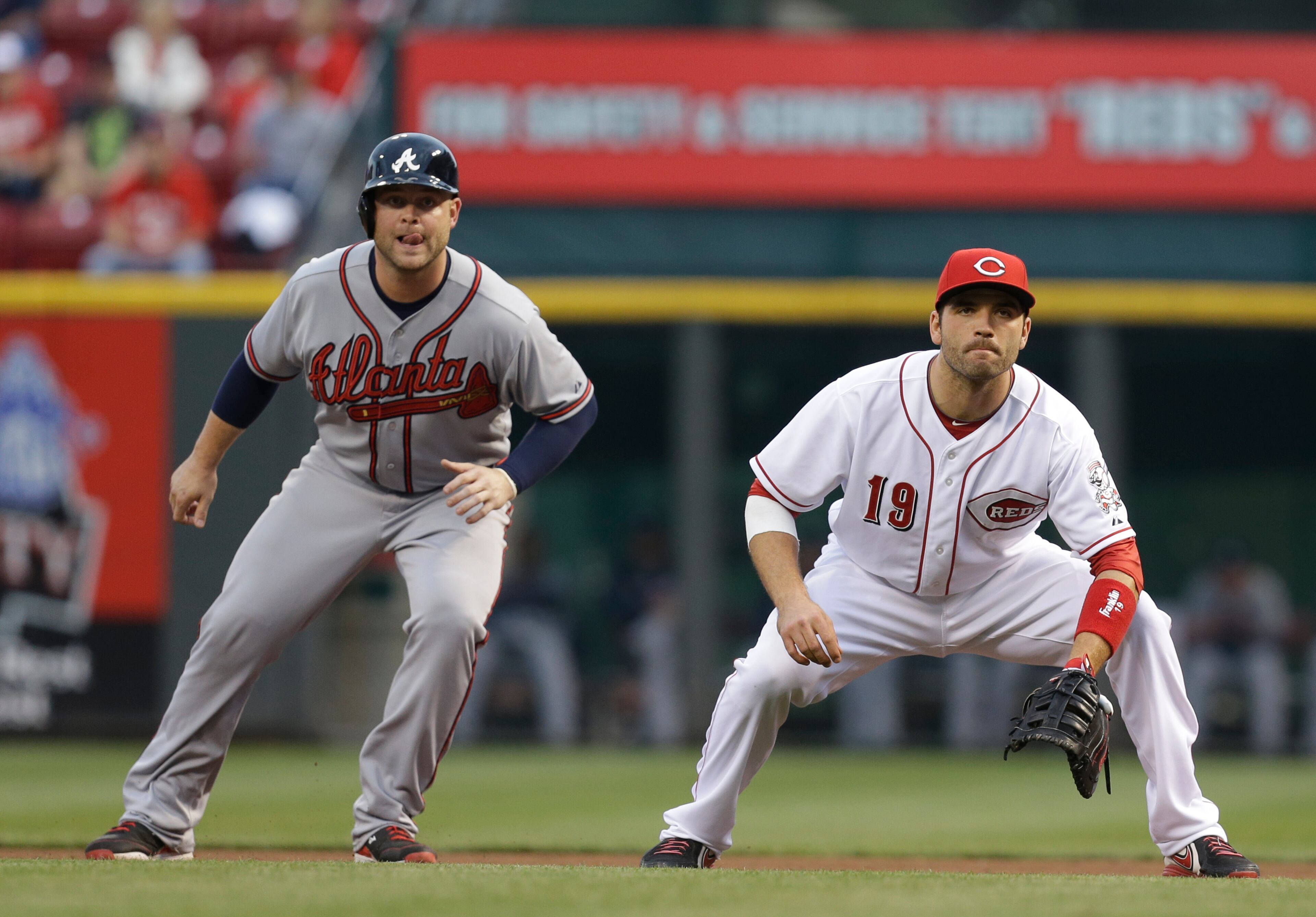 Reds' first baseman Joey Votto (19) and Atlanta Braves' Brian McCann wait for the pitch in the first.