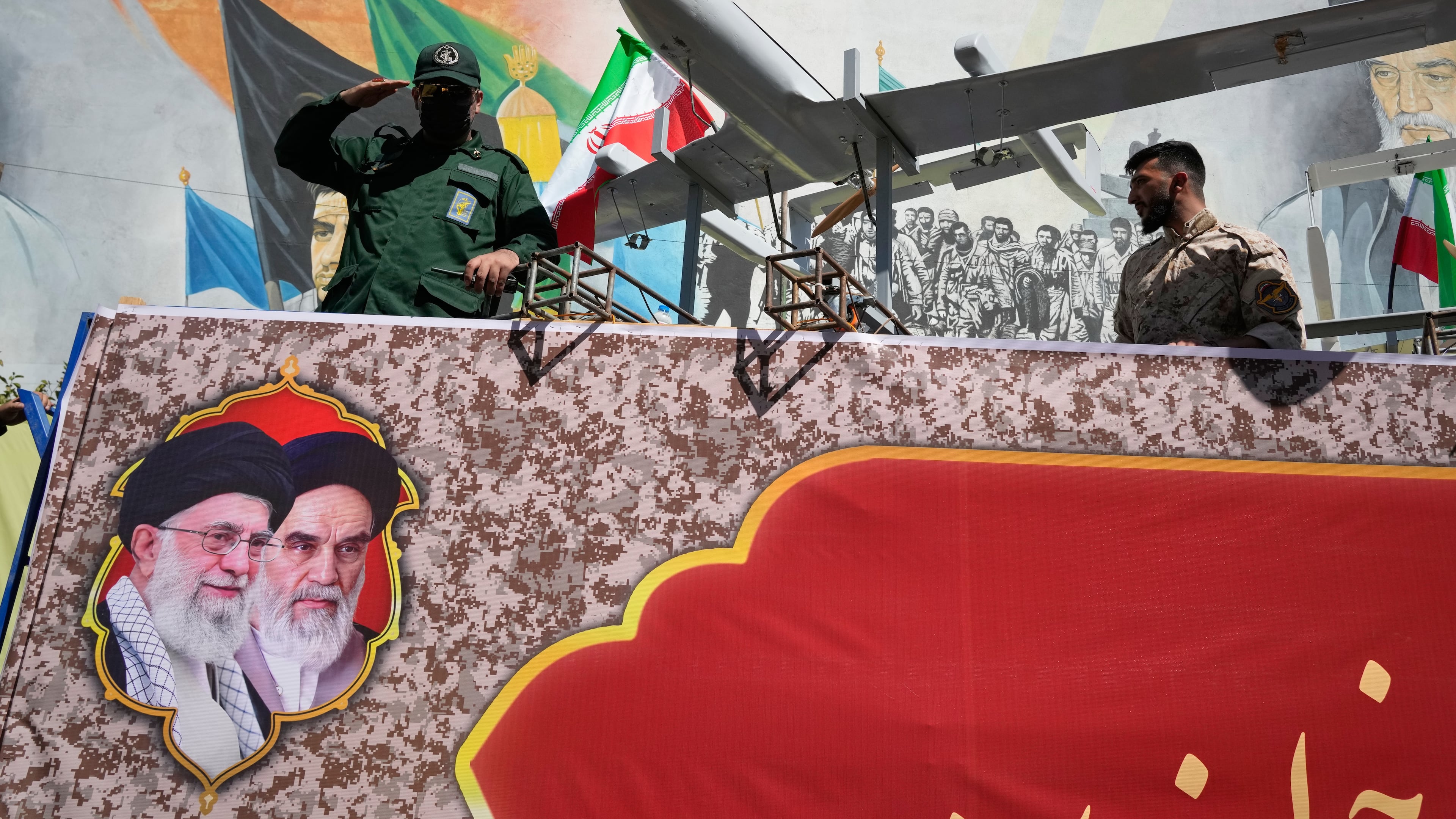 A member of Iran's Revolutionary Guard salutes while riding on a float displaying drones during the state-organized "Janfada," or "Sacrifice for Iran," military-style parade in Tehran, Iran, Friday, Sept. 18, 2026. (AP Photo/Vahid Salemi)