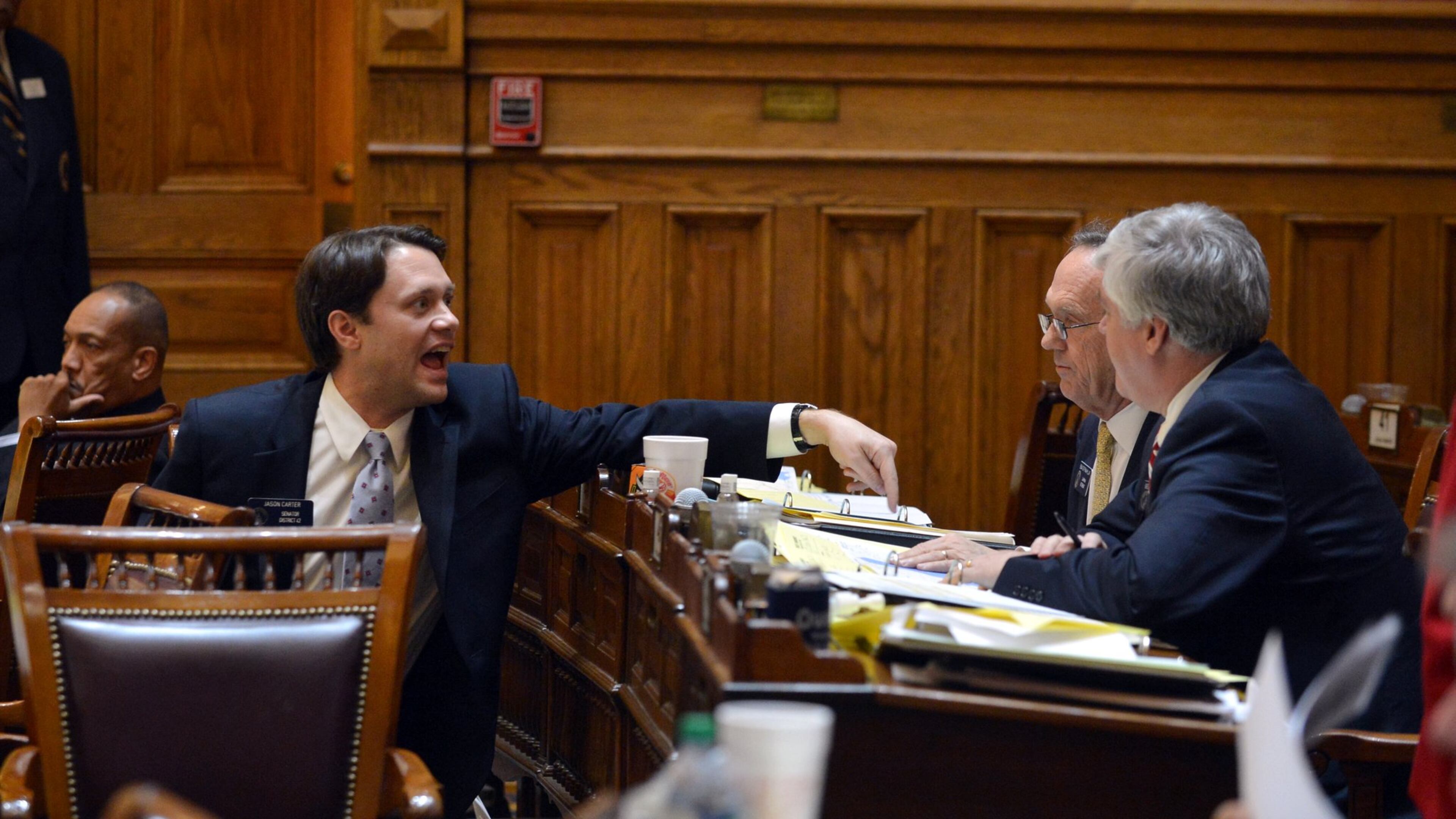 Sen. Jason Carter, left, argues with Senate Bill 270 sponsor Fran Miller, center and Bill Cowsert, who supported the bill that would create the city of Lakeside in DeKalb County. Carter spoke against the bill but did not vote. BRANT SANDERLIN /BSANDERLIN@AJC.COM
