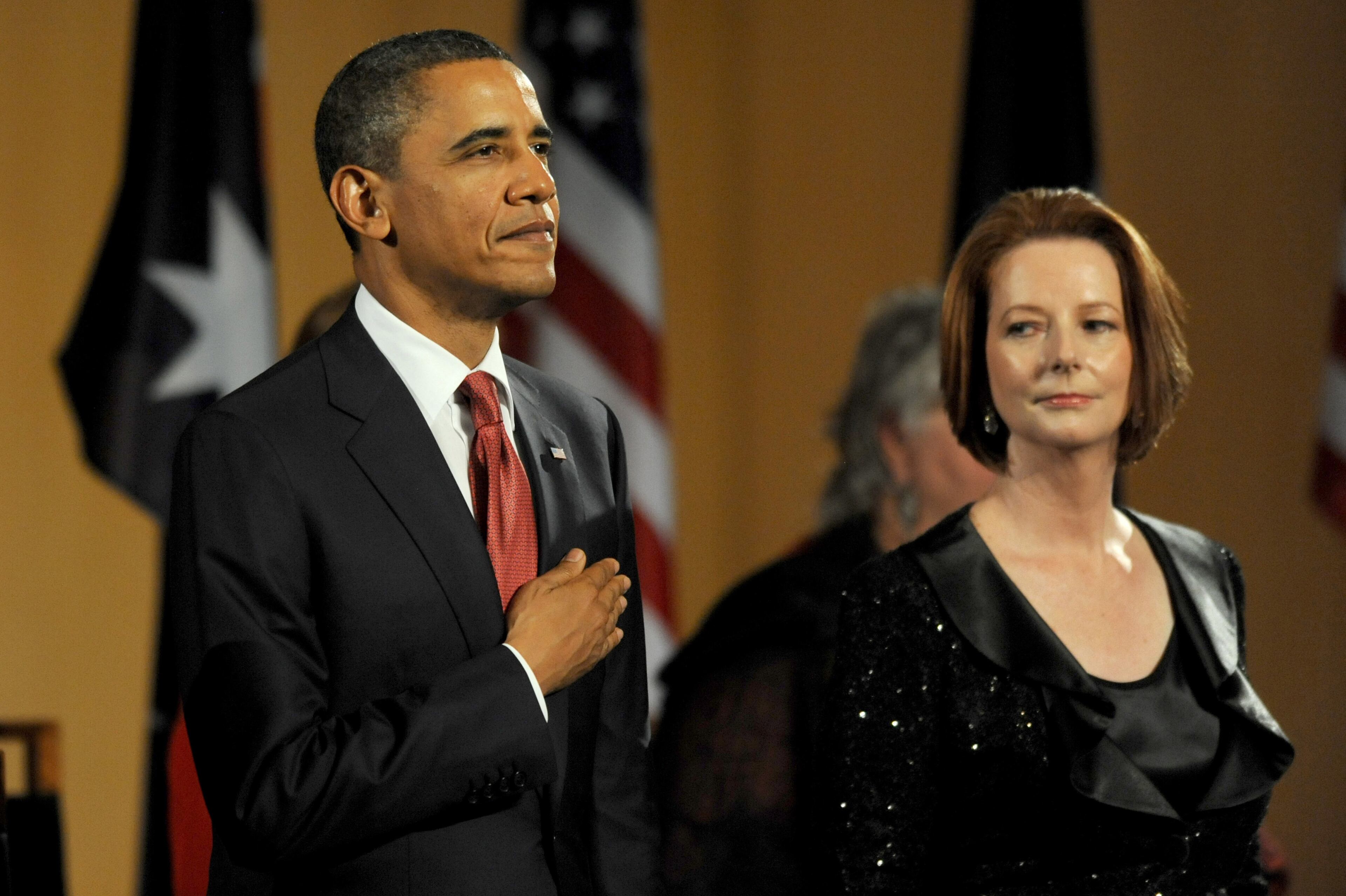 Australian Prime Minister Julia Gillard watches US President Barack Obama during the playing of the national anthems before a parliamentary dinner on the first day of his 2-day visit to Australia, on November 16, 2011 in Canberra, Australia. The President will today receive a Cermeonial Welcome, attend a bi-lateral meeting and hold a joint media conference with Julia Gillard, and attend a Parliamentary Dinner this evening, before addressing Parliament and heading to Darwin tomorrow. (Photo by Alan Porritt - Pool/Getty Images)