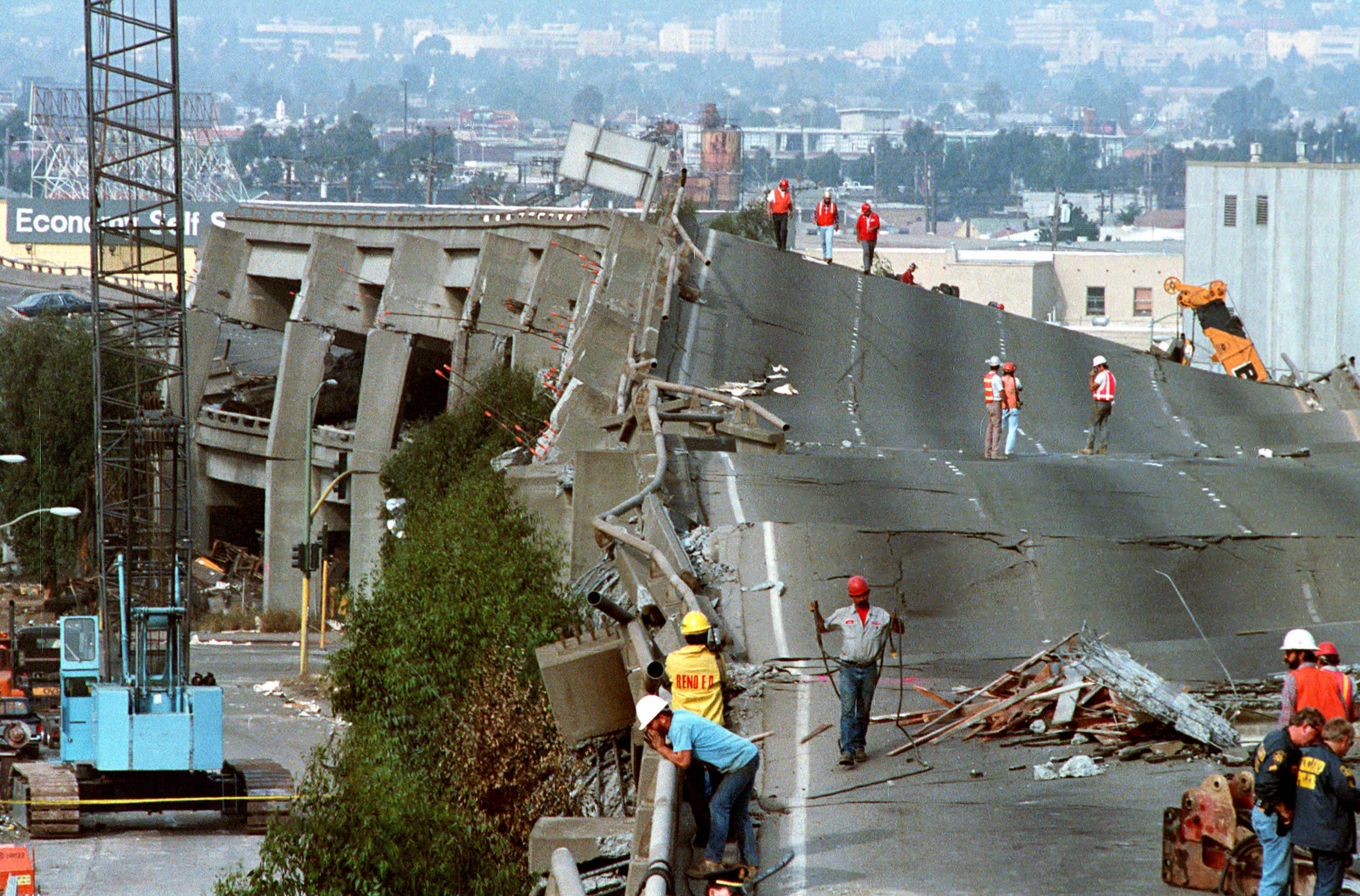 FILE - In this Oct. 19, 1989 file photo, workers check the damage to Interstate 880 in Oakland, Calif., after it collapsed during the Loma Prieta earthquake two days earlier. Friday is the 25th anniversary of the Loma Prieta earthquake that killed 63 people, injured almost 3,800 and caused up to $10 billion damage. (AP Photo/Paul Sakuma, file)