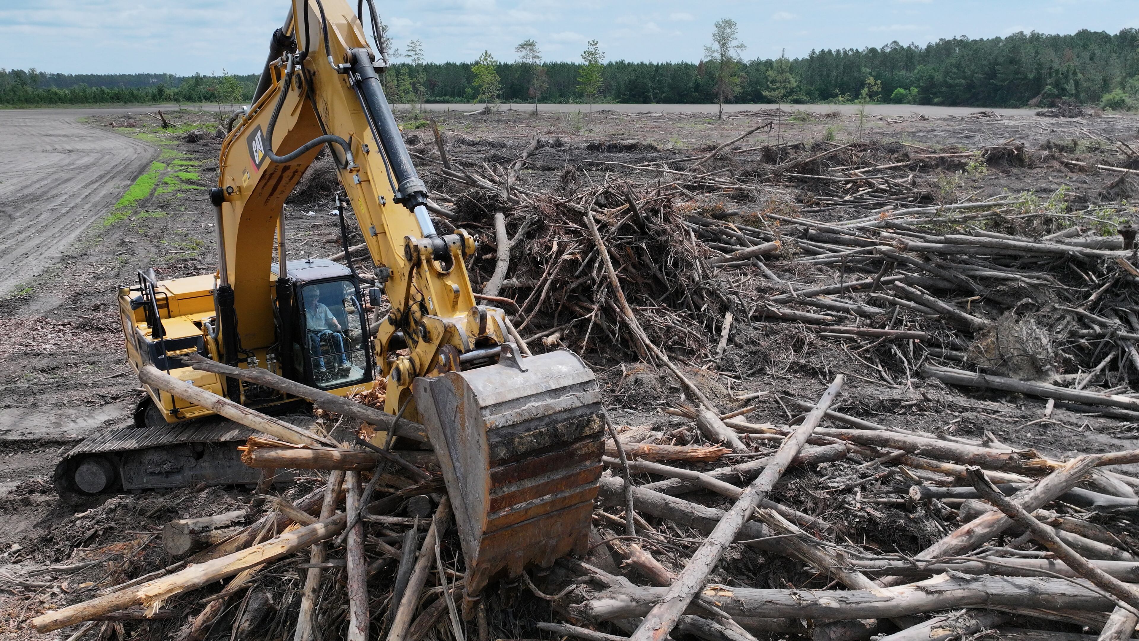 Evan Walker, nephew of Drew Walker, operates a tractor to clean up debris from downed trees on the property of Walker Farms in Wilsonville, May 28, 2025. Drew Walker knew Hurricane Helene was headed for Florida‘s Big Bend region, but couldn’t imagine it would ravage swathes of farm and timberland more than 100 miles inland. (Hyosub Shin/AJC)