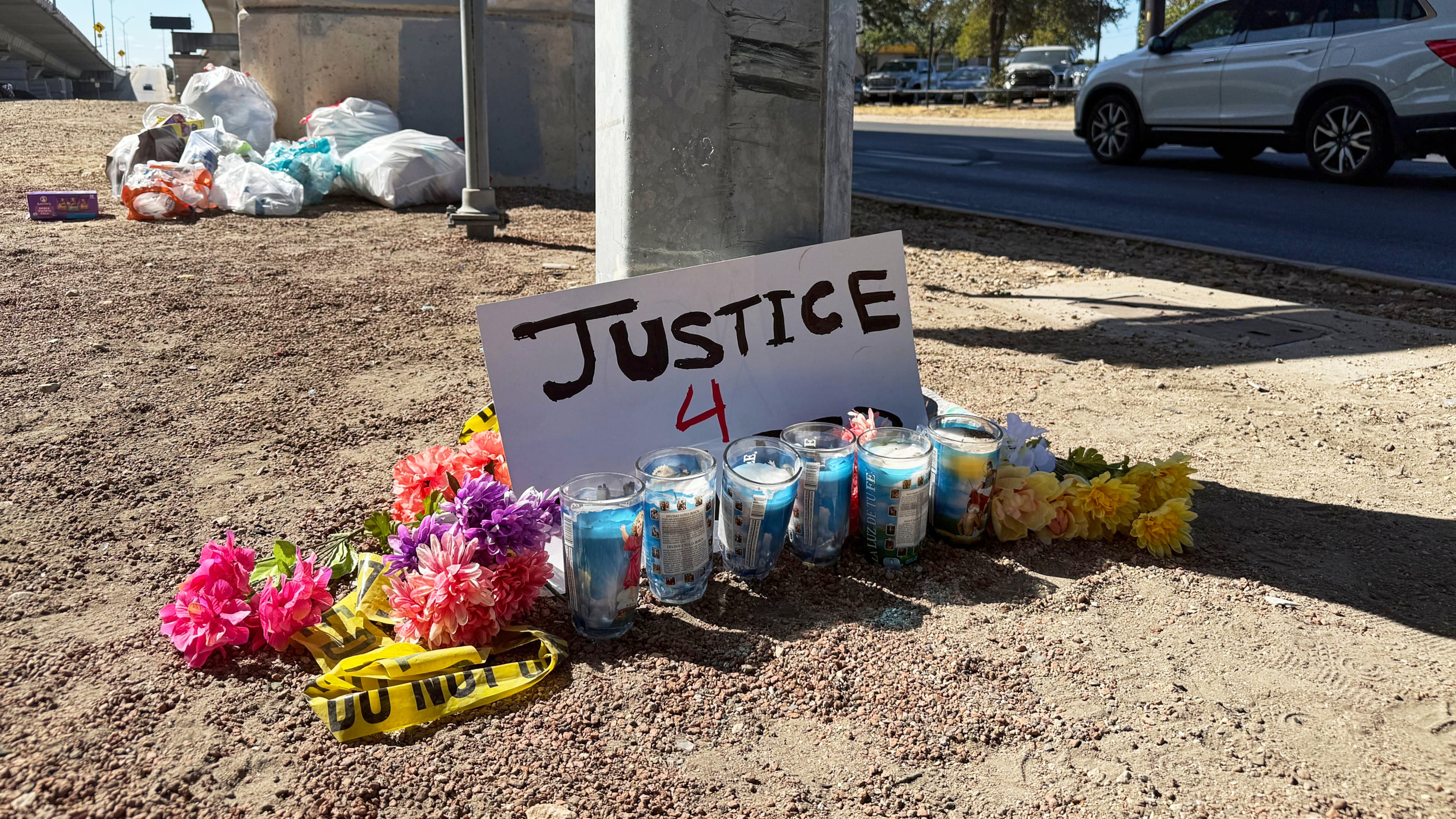 Flowers and candles are placed, Monday, Sept. 21, 2026, near the site where an ICE officer shot a Venezuelan man during a traffic stop the day before, in Austin, Texas. (AP Photo/Jesse Bedayn)