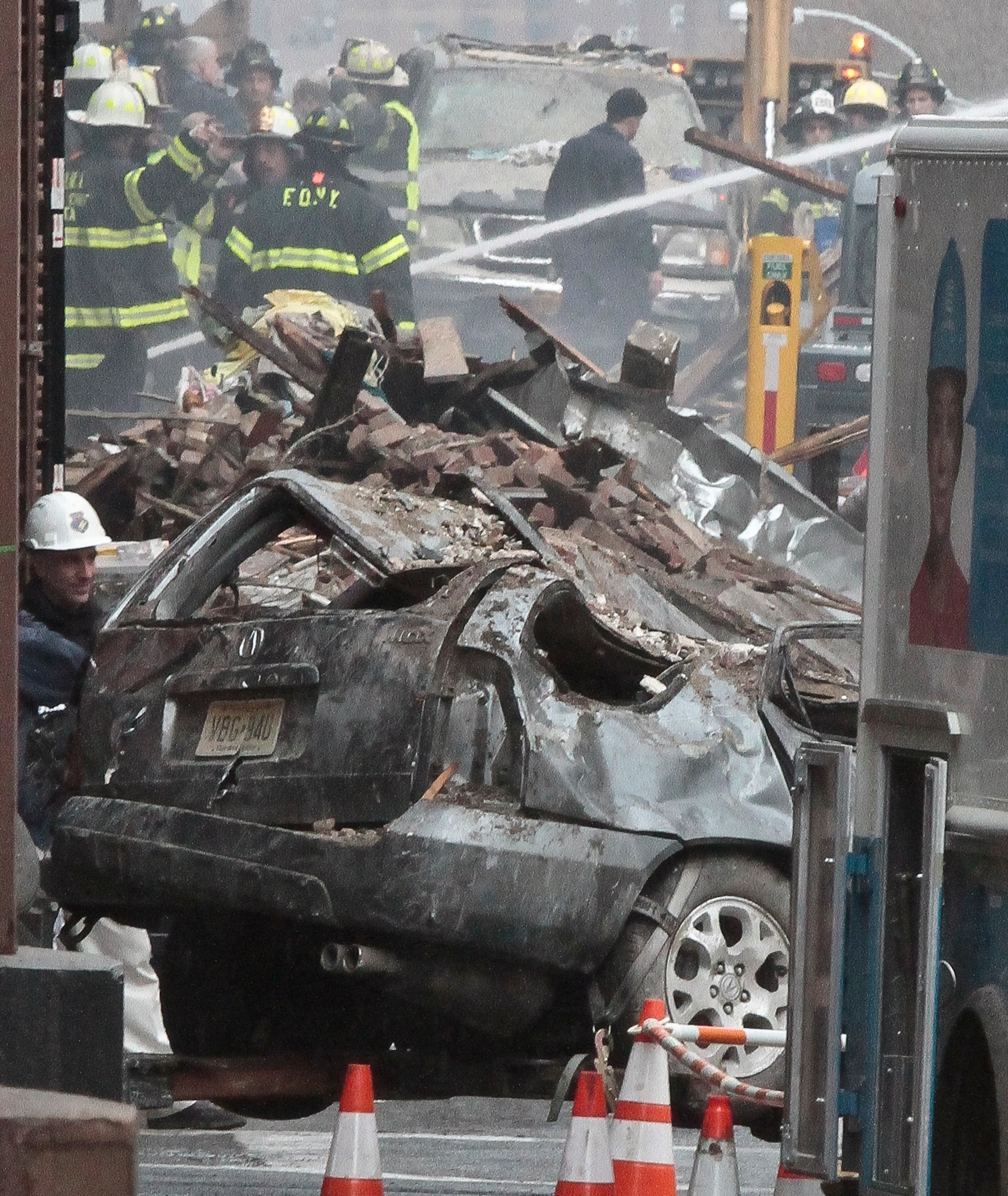 Firefighters continue to investigate and remove debris from an explosion in Harlem, Wednesday, March 12, 2014 in New York. A gas leak triggered an explosion that shattered windows a block away, rained debris onto elevated commuter railroad tracks close by, cast a plume of smoke over the skyline and sent people running into the streets. (AP Photo/Bebeto Matthews)