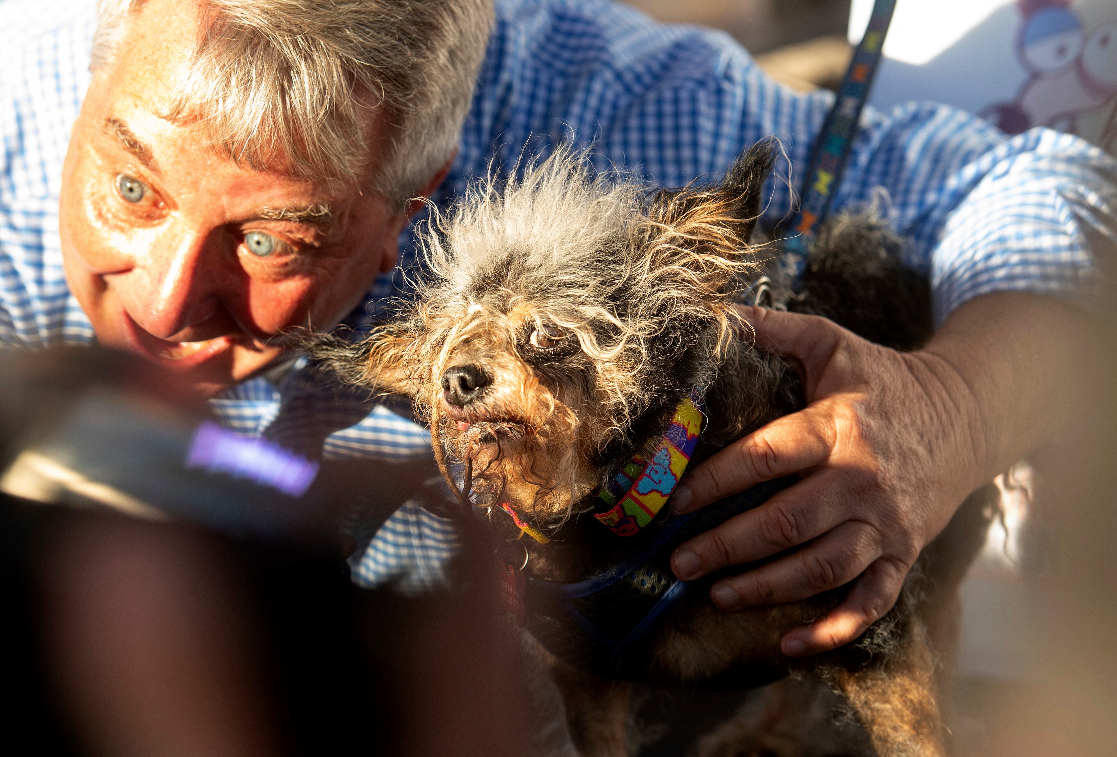 Scamp the Tramp is held after taking top honors in the World's Ugliest Dog Contest at the Sonoma-Marin Fair in Petaluma, Calif., Friday, June 21, 2019. At left is Kerry Sanders, a reporter who served as one of the judges. (AP Photo/Noah Berger)