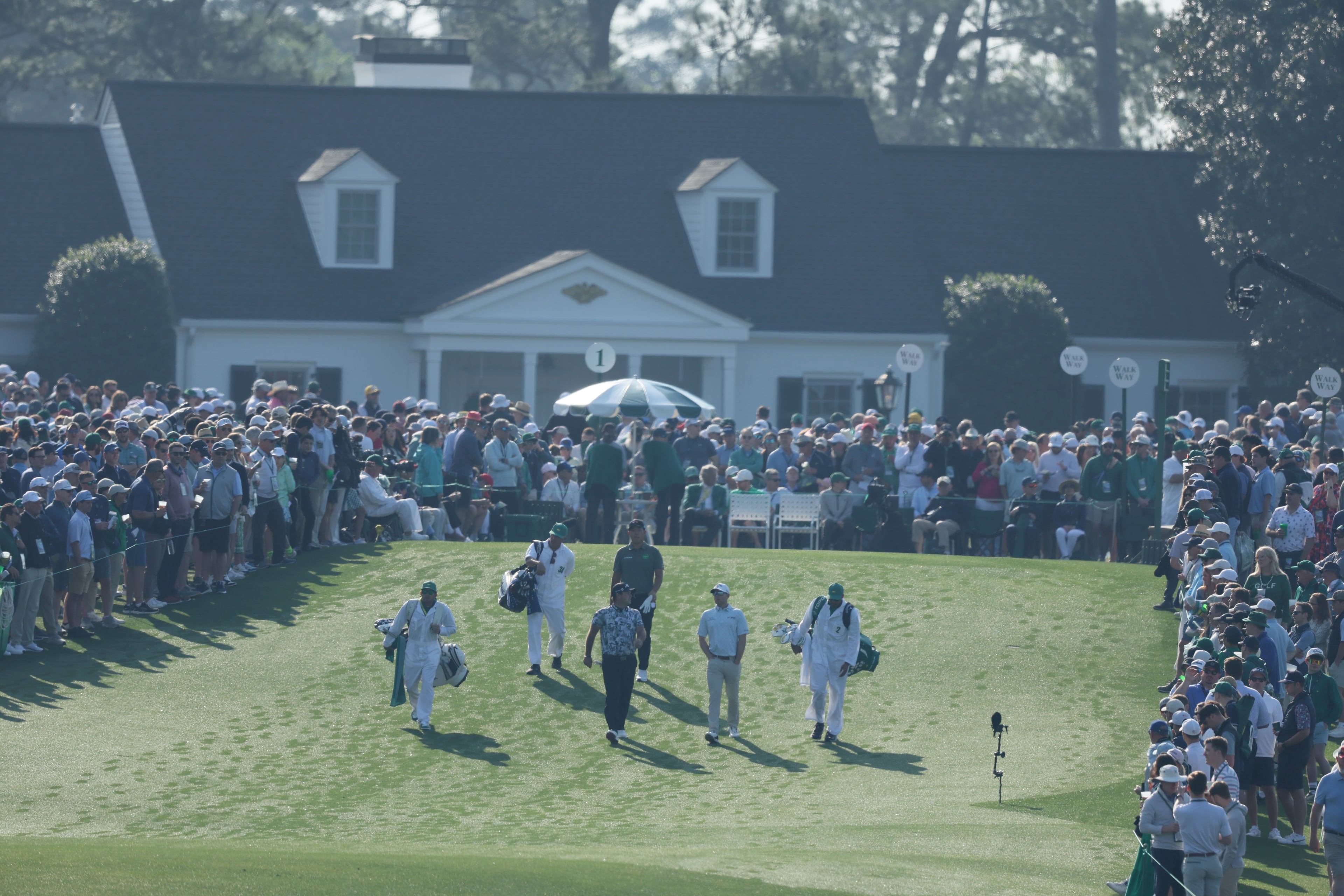 Group of Patrick Reed, Max Greyserman and Byeong Hun An walk down first fairway, during first round of the Masters golf tournament, at Augusta National Golf Club, Thursday, April 10, 2025, in Augusta, Ga. (Jason Getz / AJC)