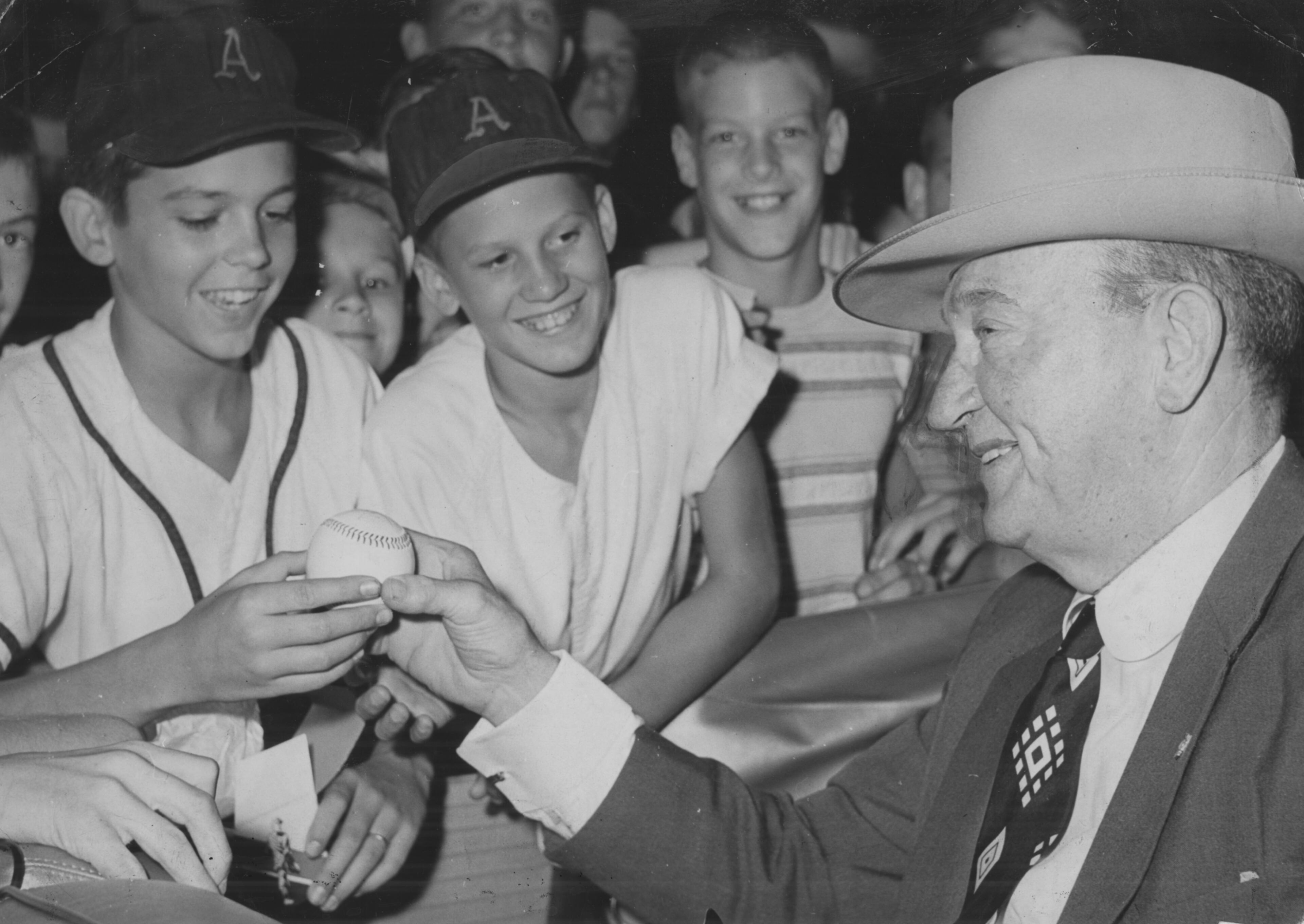 Former baseball great Ty Cobb autographs a ball for Chris Alford and Tommy Broome. (BILL YOUNG/AJC staff) Undated photo