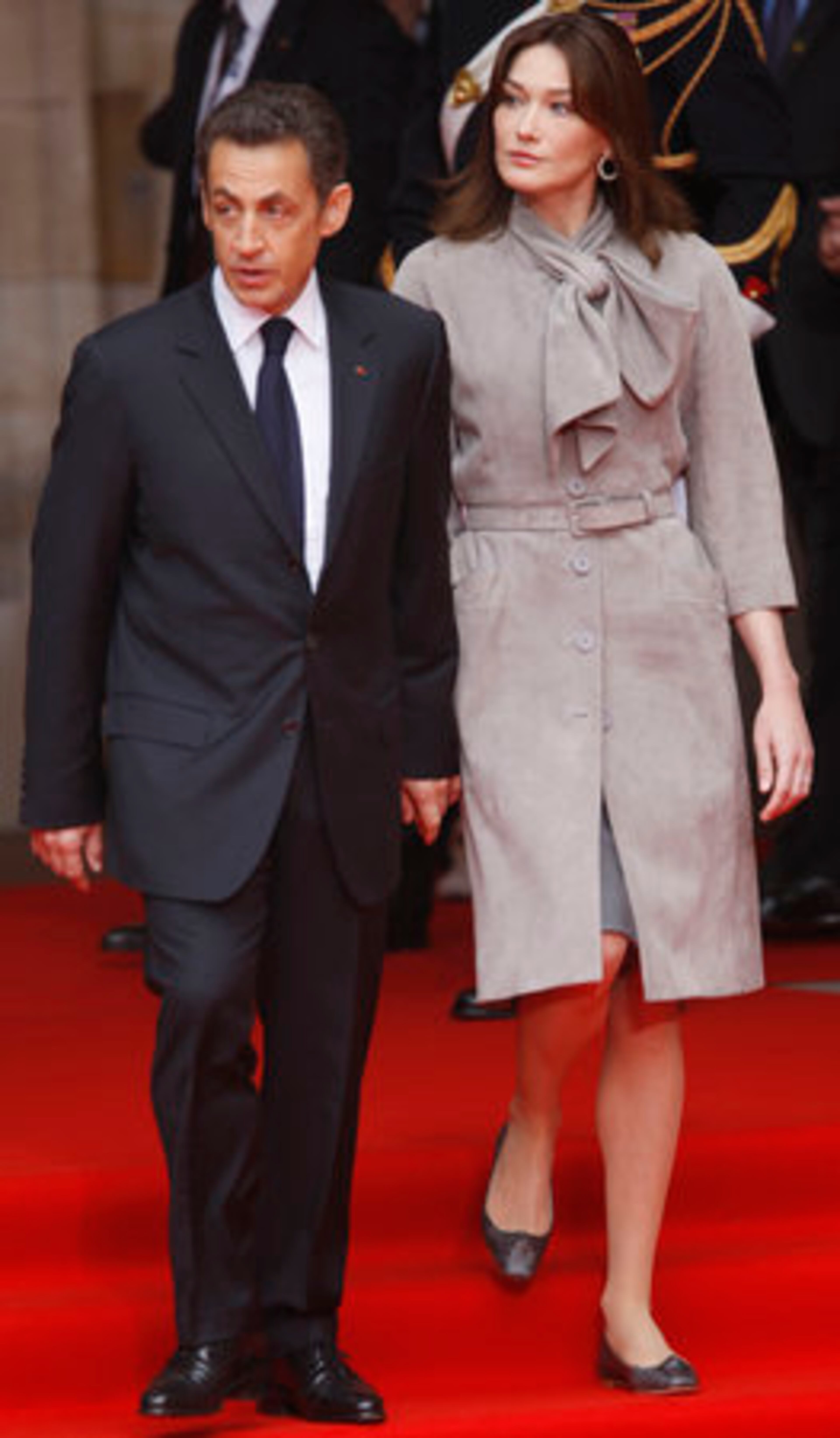 For Carla: "Plus 4" for tailoring. The bell sleeves are perfection. But "Minus 72" for the buttons-and-belt combo. We have no idea what Carla's wearing under there and we're dying to find out.