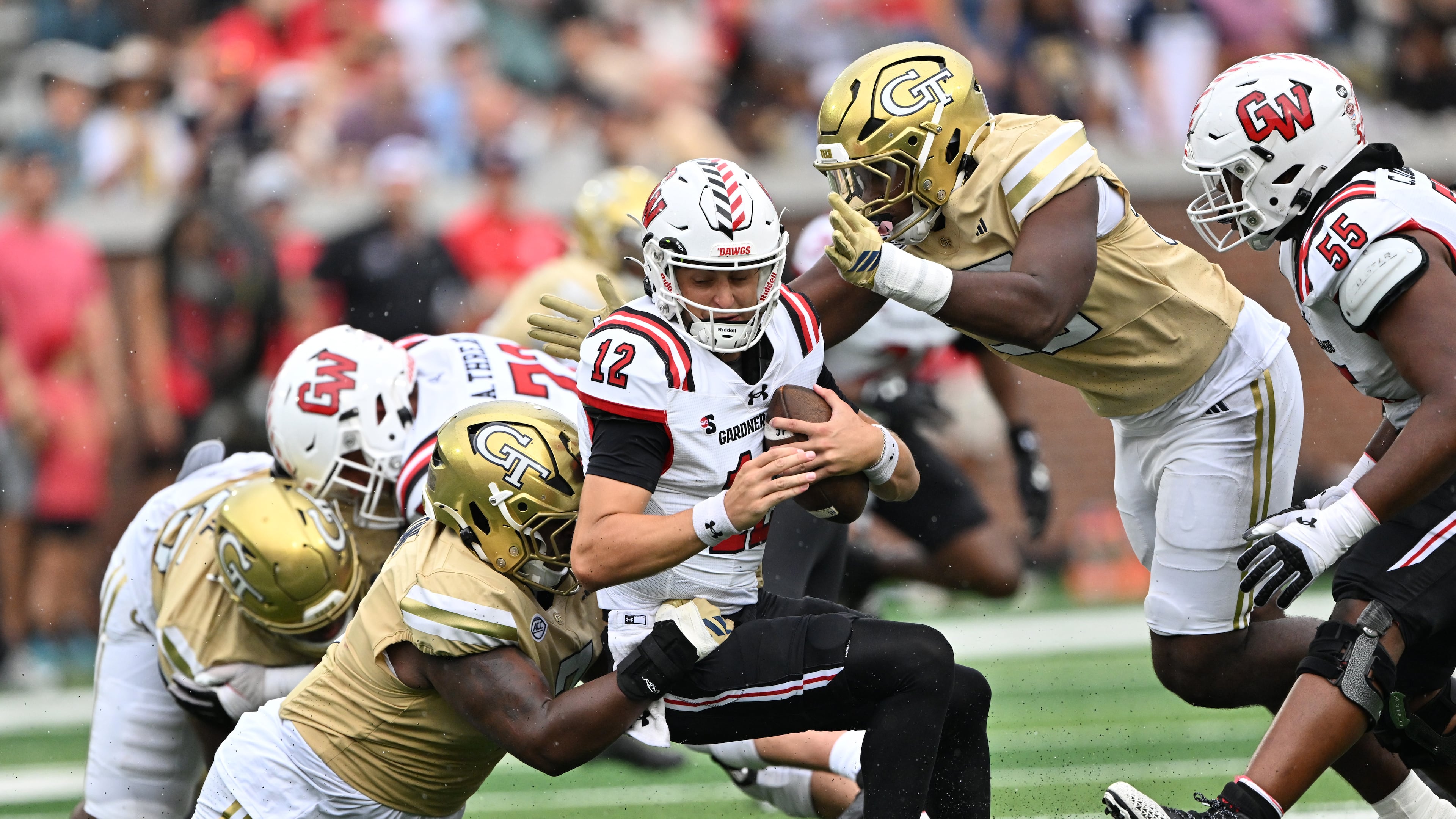 Gardner-Webb quarterback Cole Pennington (center) gets sacked by Georgia Tech defensive lineman Akelo Stone (7) during the first half of an NCAA game Sept. 6, 2025 in Atlanta. (Hyosub Shin/AJC)