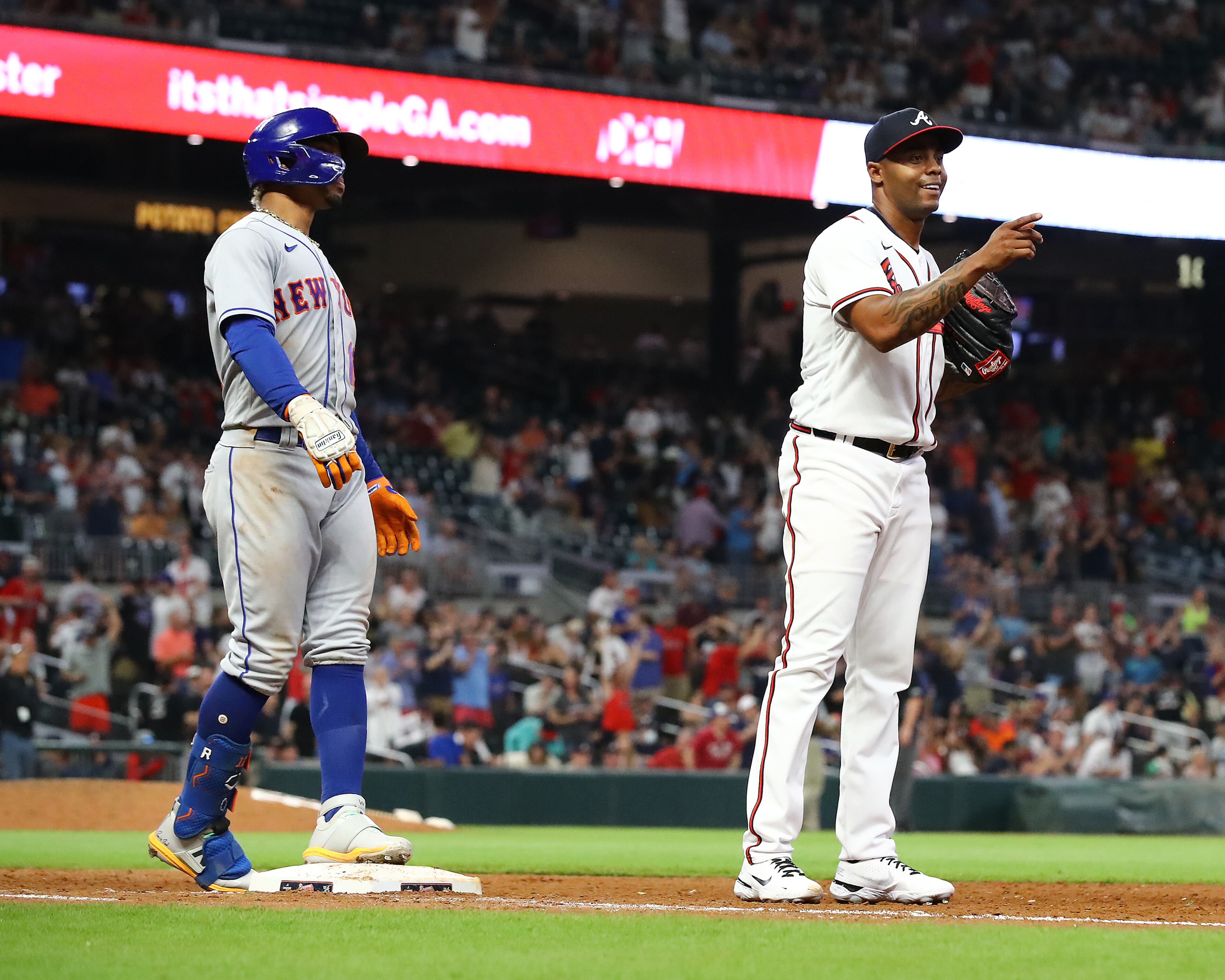 Braves closing pitcher Raisel Iglesias points toward first baseman Matt Olson after Olson made a play on a hot grounder down the first base line by New York Mets batter Francisco Lindor (left) and threw to Iglesias for the final out of the game during the ninth inning to seal a 5-0 shutout in a MLB baseball game on Tuesday, August 16, 2022, in Atlanta. “Curtis Compton / Curtis Compton@ajc.com