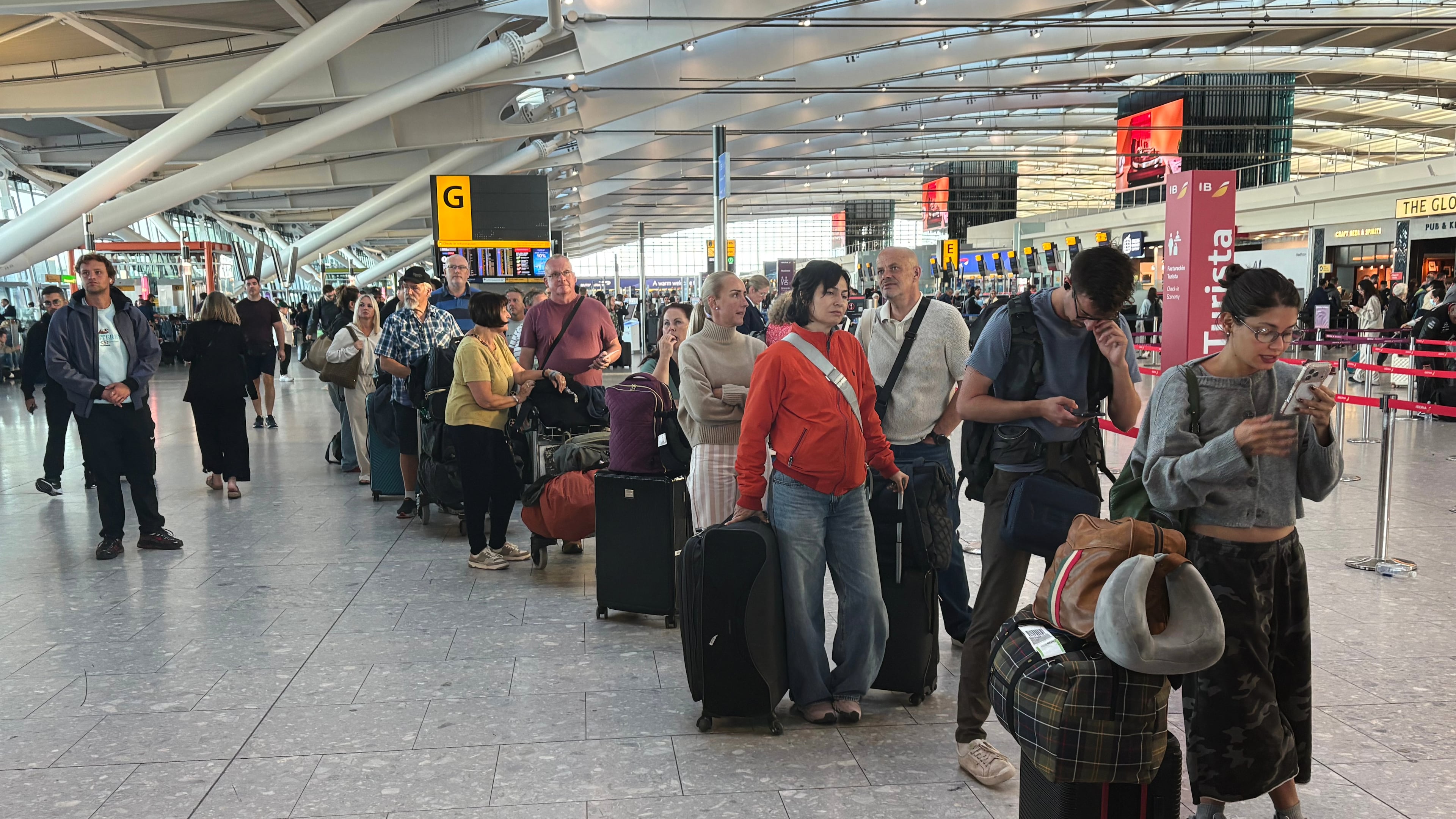 Passengers wait in line at Heathrow Airport in London, during an air traffic control problem that disrupted travel across Britain. (Jonathan Brady/PA via AP)
