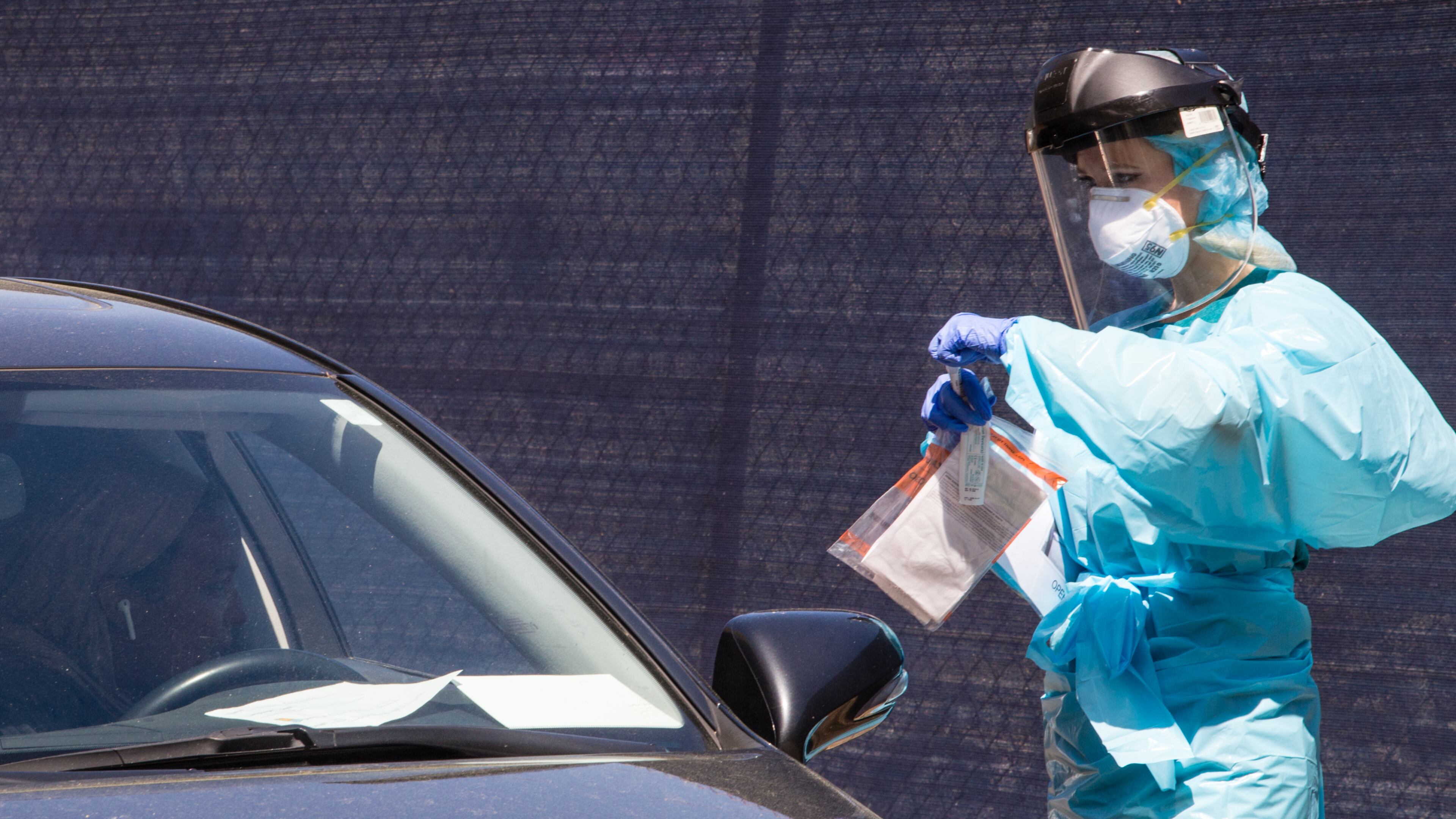 At the testing tent, Natalie Ali, a nurse volunteer puts a sample taken from the driver into a medical bag to be taken for testing Friday, April 3, 2020. Ethne Health in partnership with the City of Clarkston, community churches and food banks provides free covid testing for people showing symptoms who live in the Clarkston area. Results will take approximately 3 days before results will be know. The corona virus testing will continue on Saturday. (Jenni Girtman for the Atlanta Journal-Constitution)