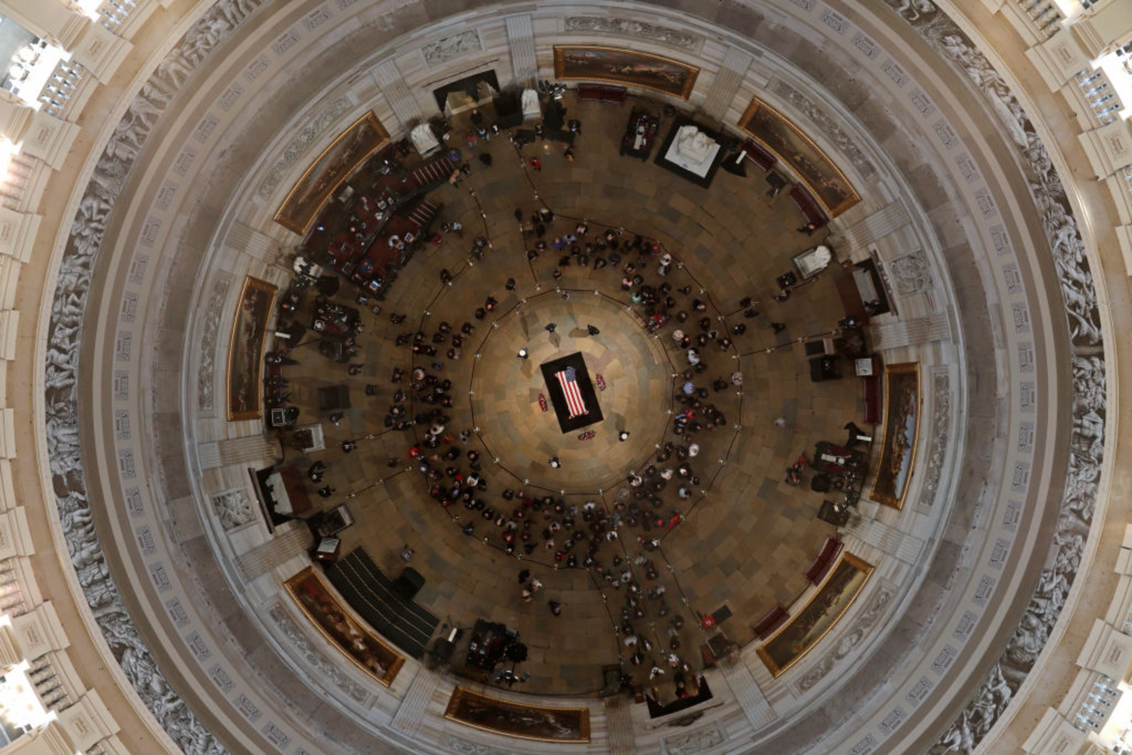 Members of the public file through the Capitol Rotunda to view the flag-draped casket of the late former President George H.W. Bush as he lies in state on December 4, 2018 in Washington, DC. A WWII combat veteran, Bush served as a member of Congress from Texas, ambassador to the United Nations, director of the CIA, vice president and 41st president of the United States. Bush will lie in state in the U.S. Capitol Rotunda until Wednesday morning.