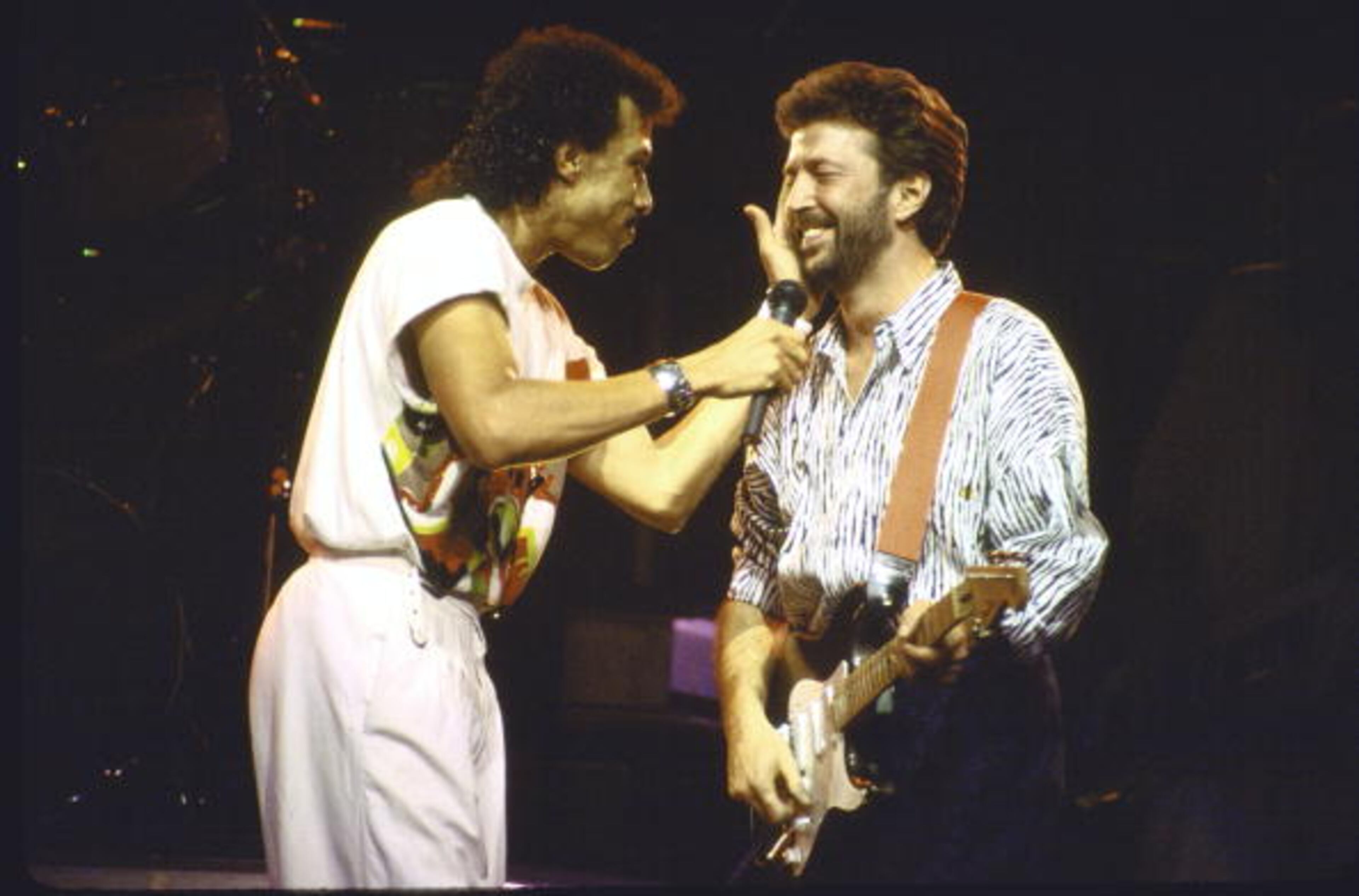 (L-R) Singer Lionel Richie and blues guitarist Eric Clapton performing on stage. (Photo by Gene Shaw//Time Life Pictures/Getty Images)